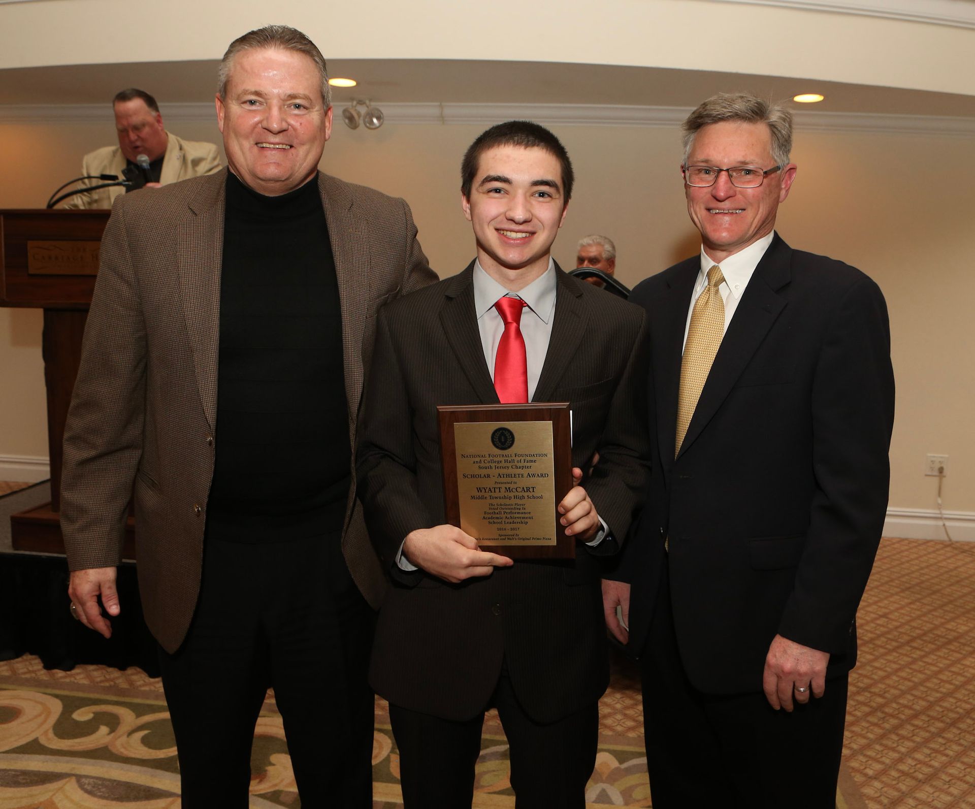 a man in a suit and tie is holding a plaque