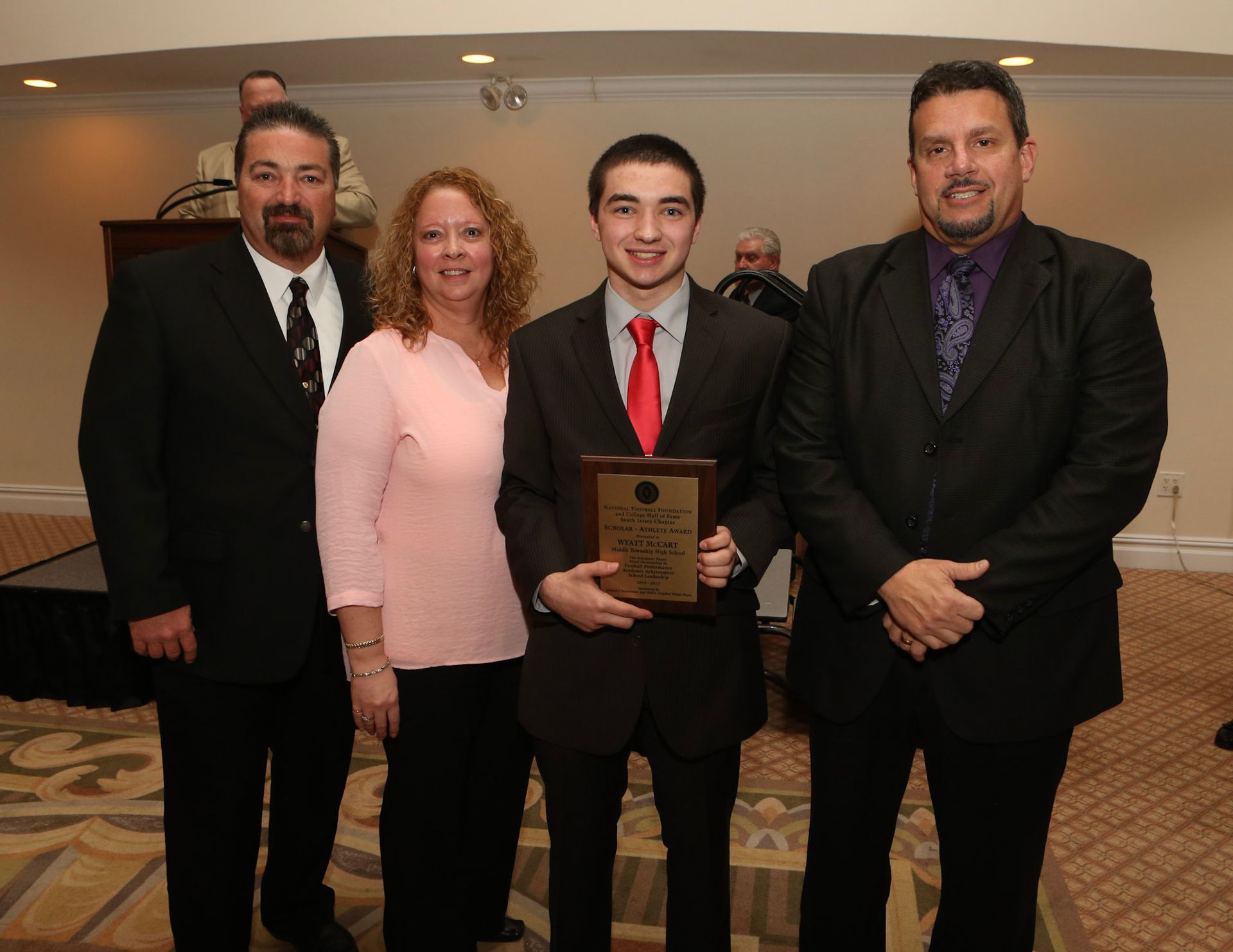a group of people posing for a picture with a man holding a plaque