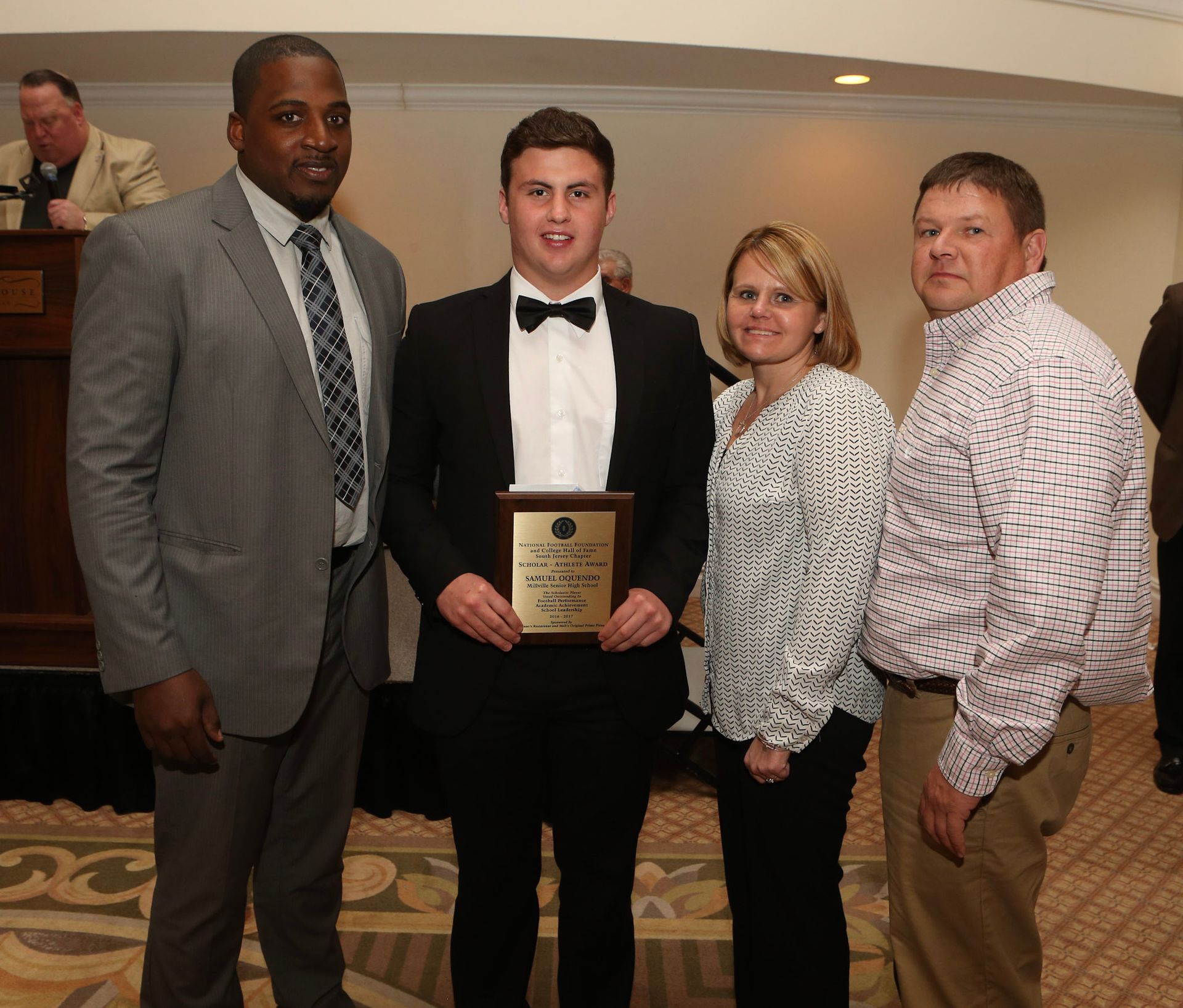 a man in a suit is holding a plaque that says ' winner ' on it