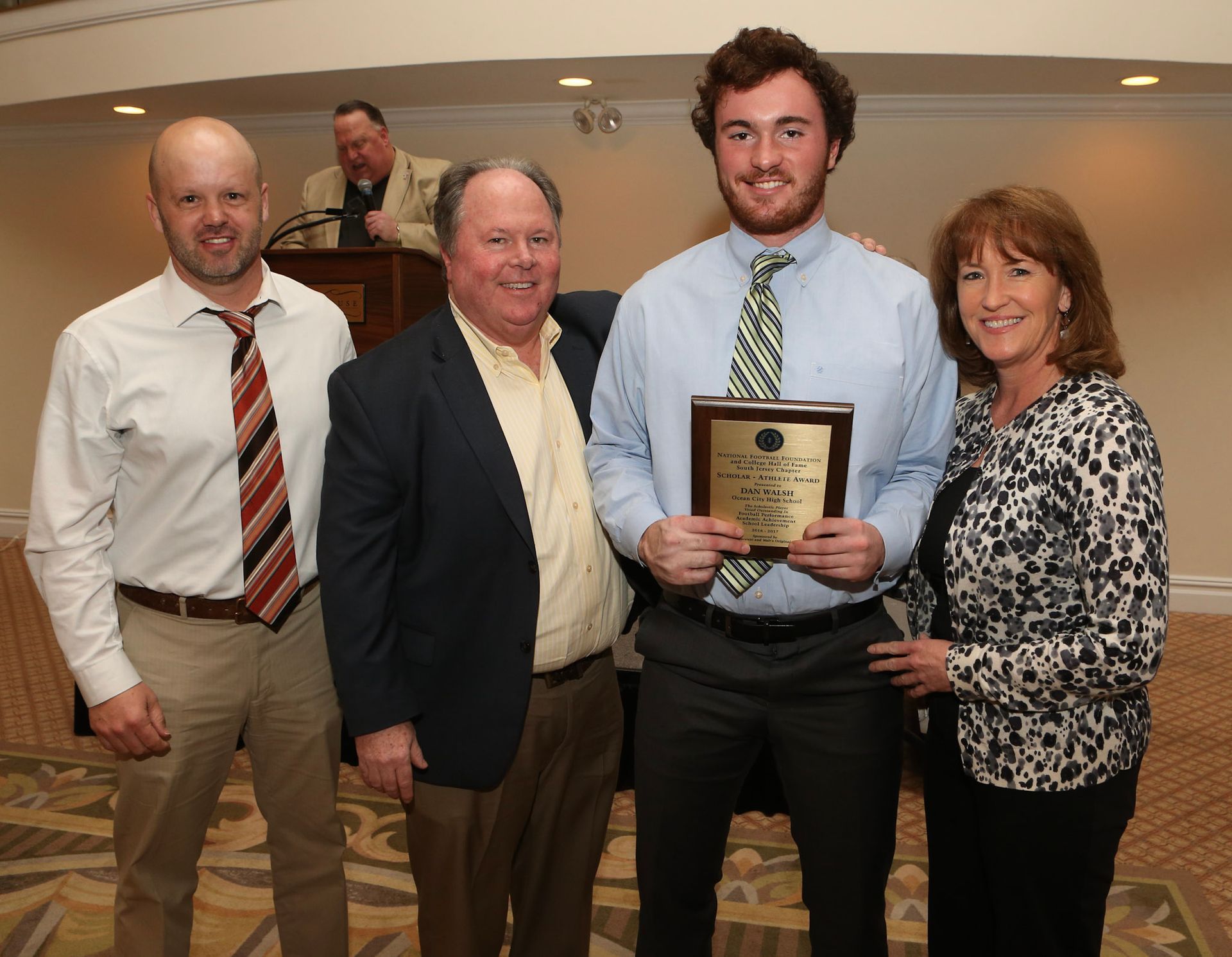 a group of people posing for a picture with a man holding a plaque