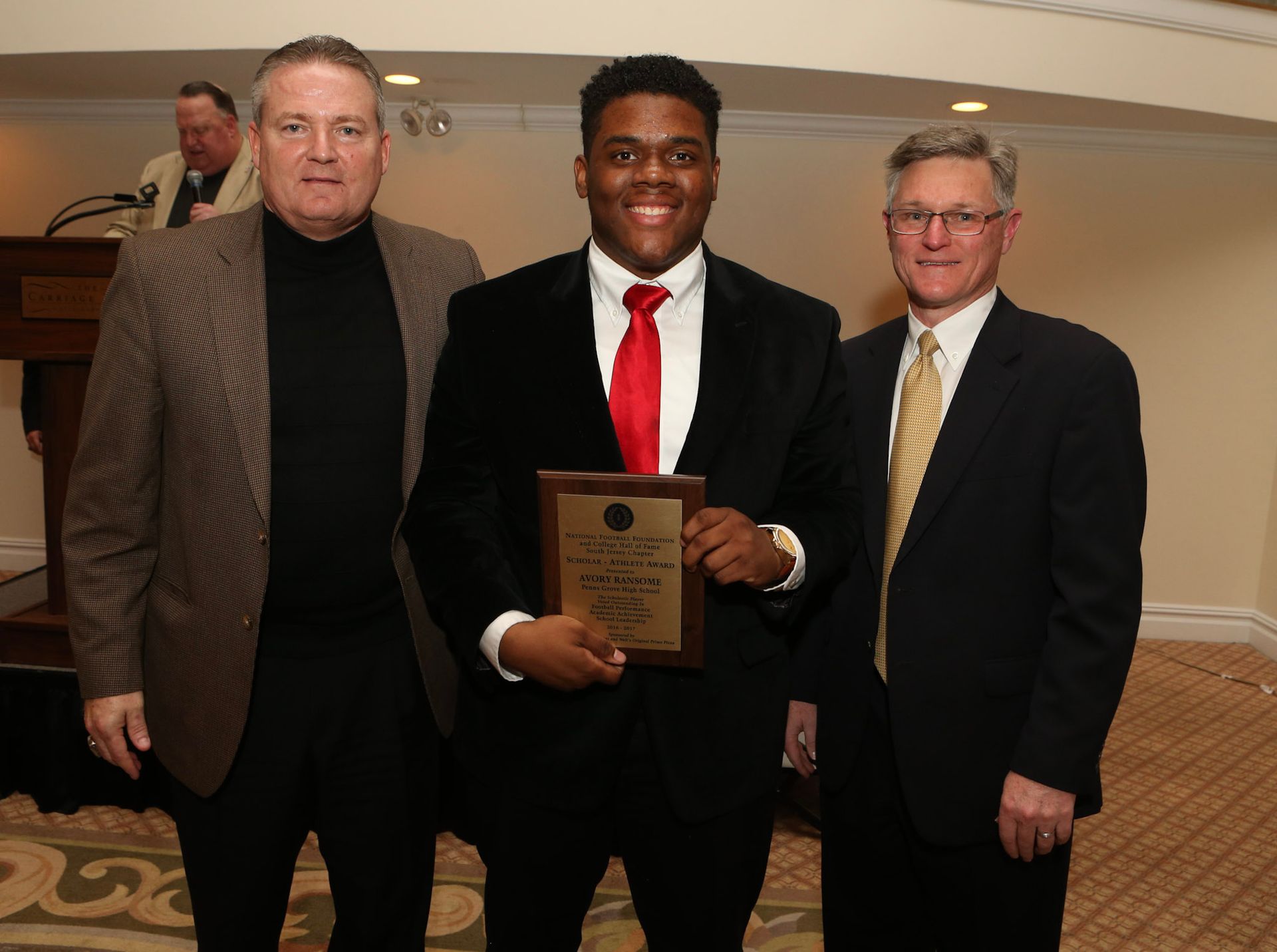 a man in a suit and tie is holding a plaque