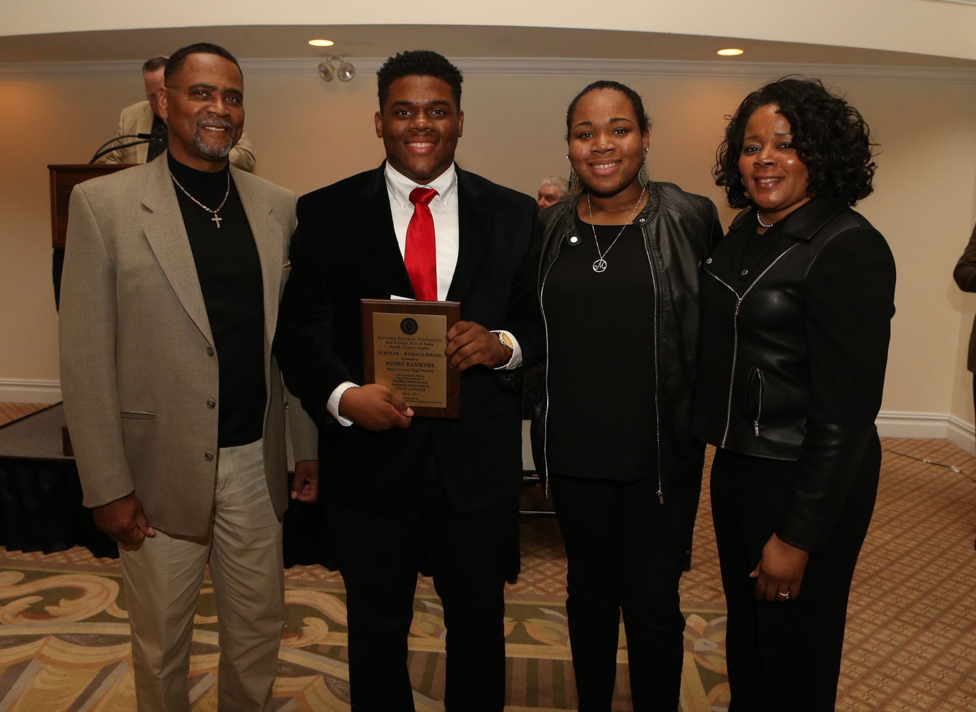 a man in a suit is holding a plaque that says ' winner ' on it