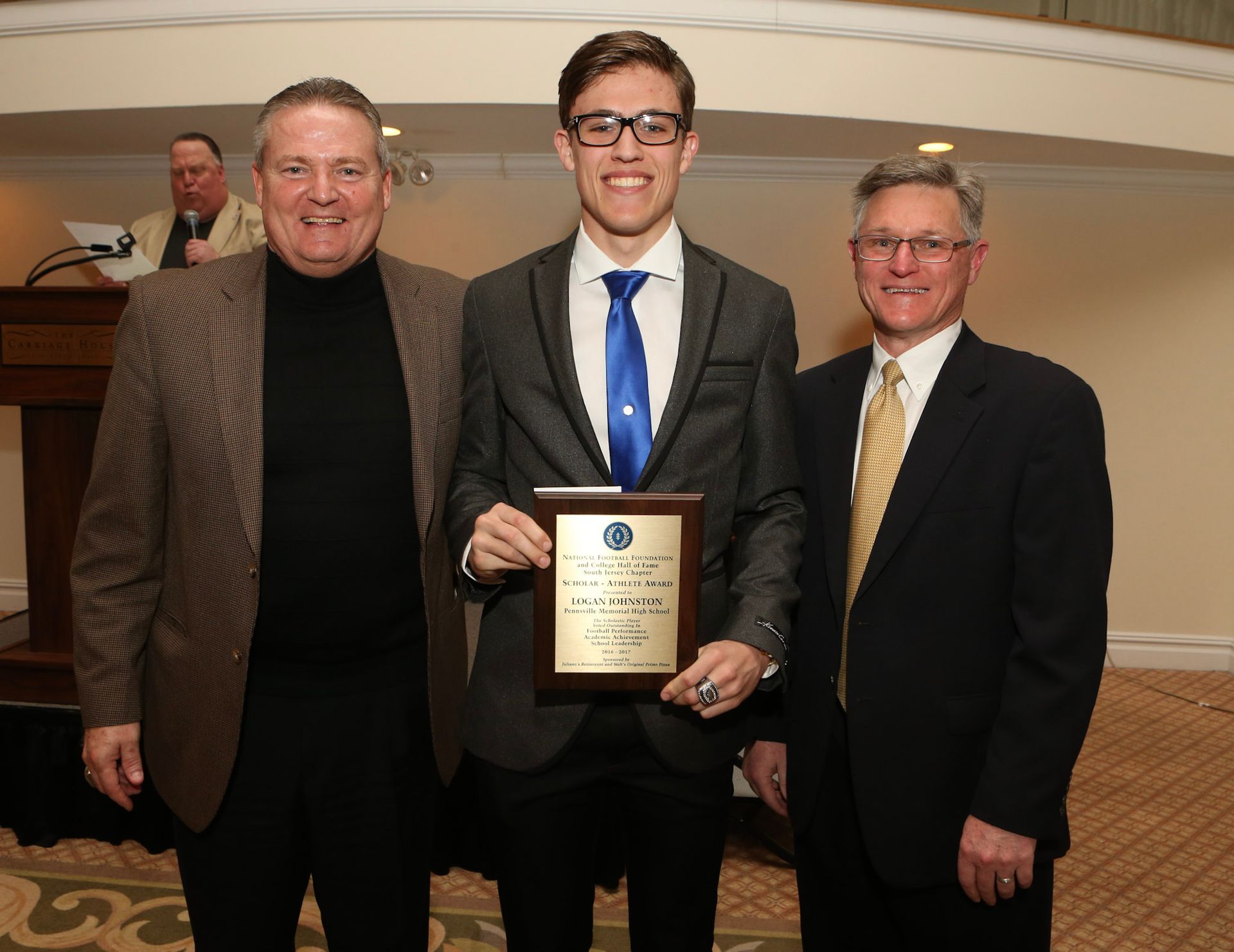 a man in a suit and tie is holding a plaque