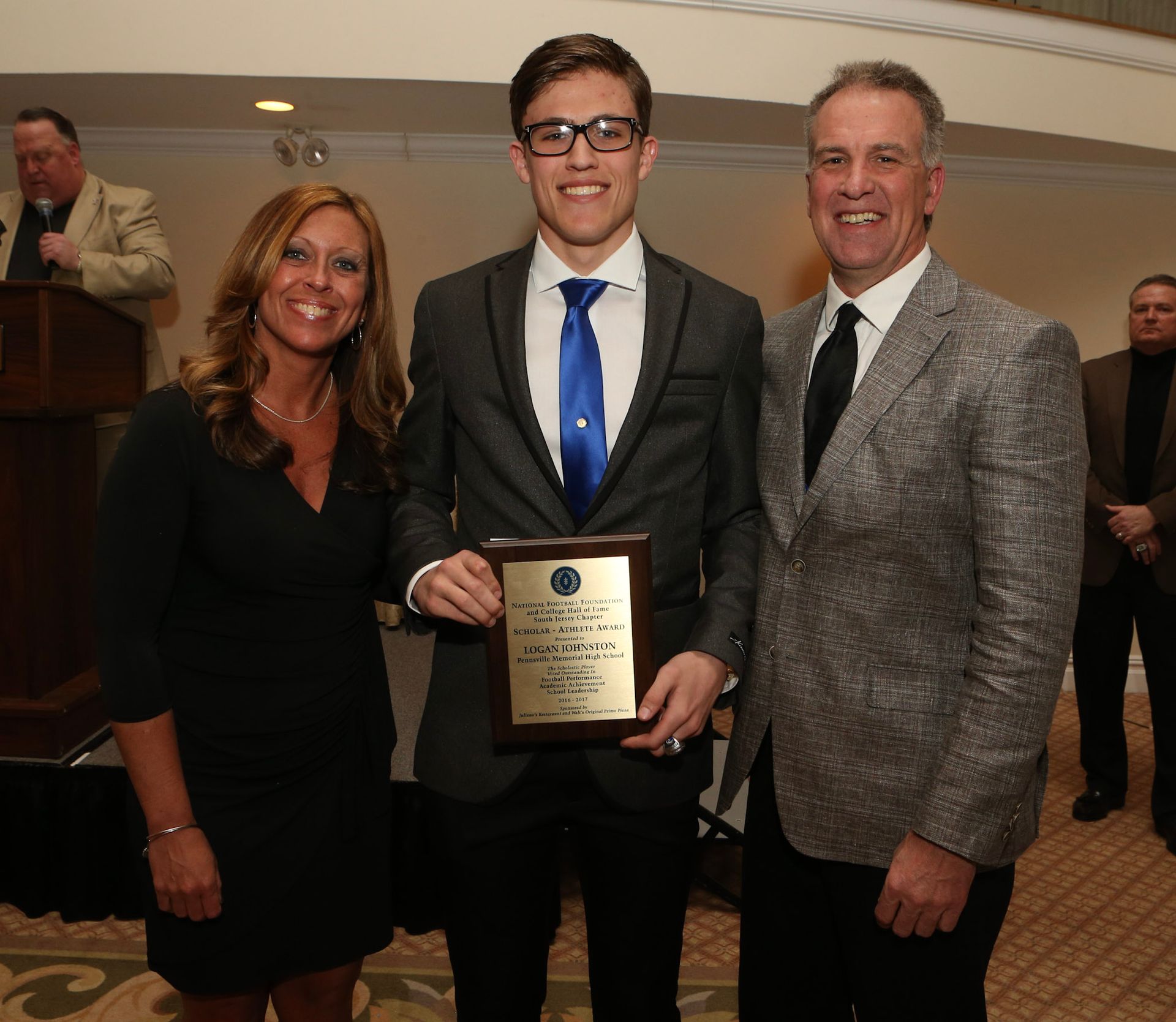 a man in a suit and tie is holding a plaque