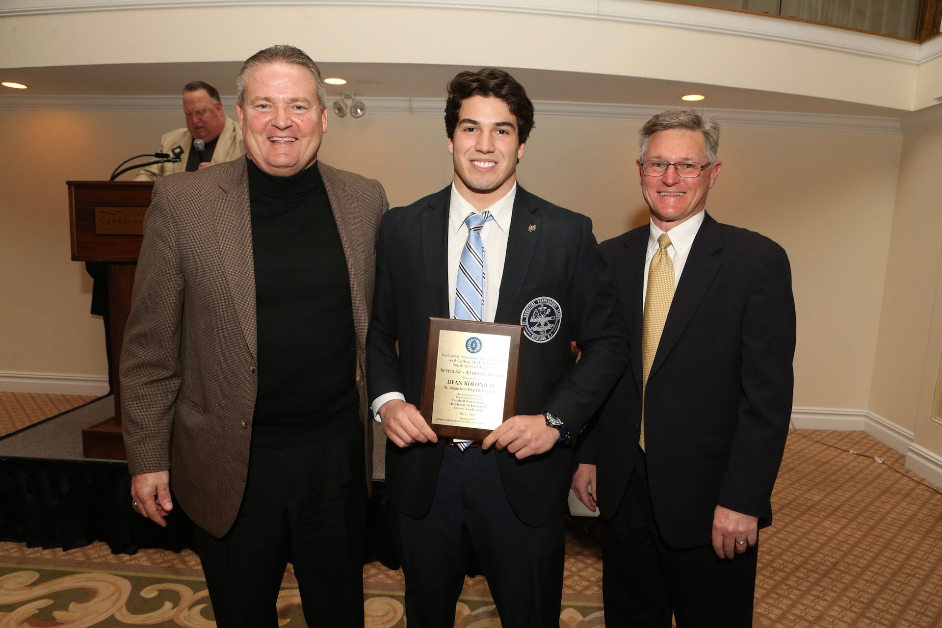 a man in a suit and tie is holding a plaque