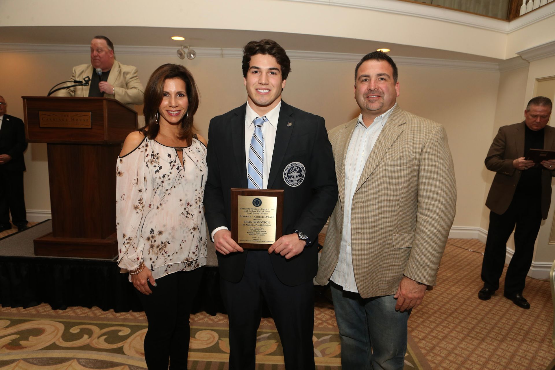 a man in a suit and tie is holding a plaque