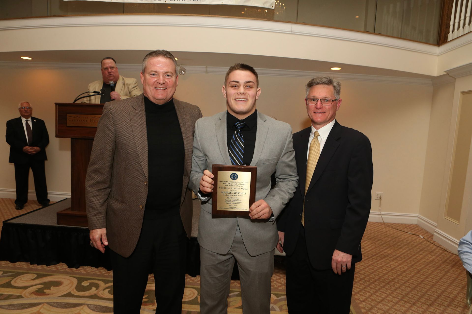 a man in a suit is holding a framed award