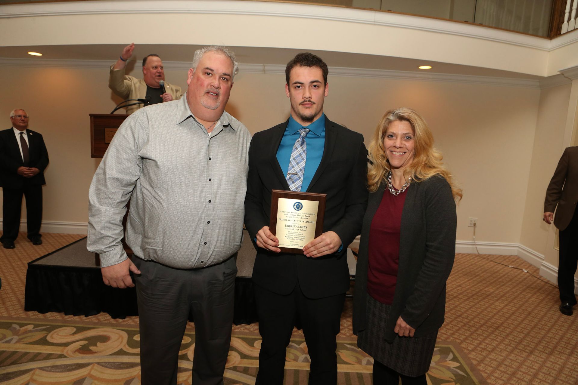 a man in a suit and tie is holding a plaque