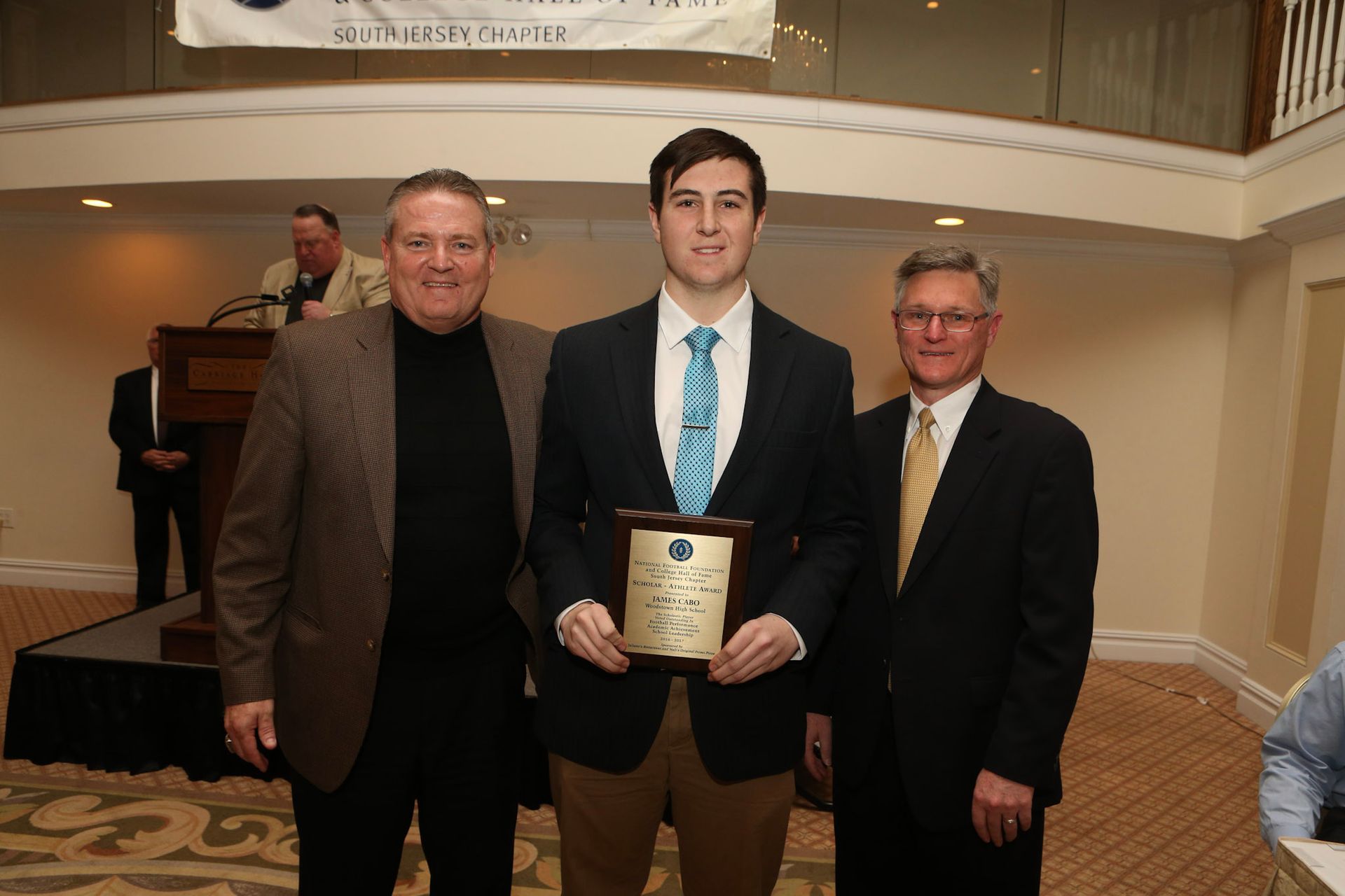 a man in a suit and tie is holding a plaque