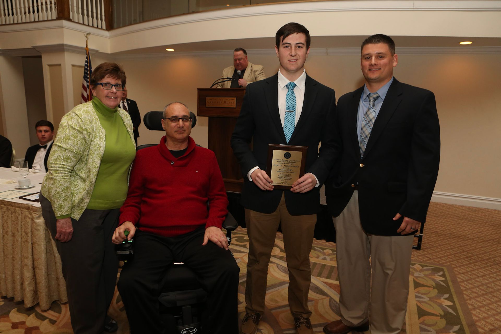 a group of people posing for a picture with one man in a wheelchair