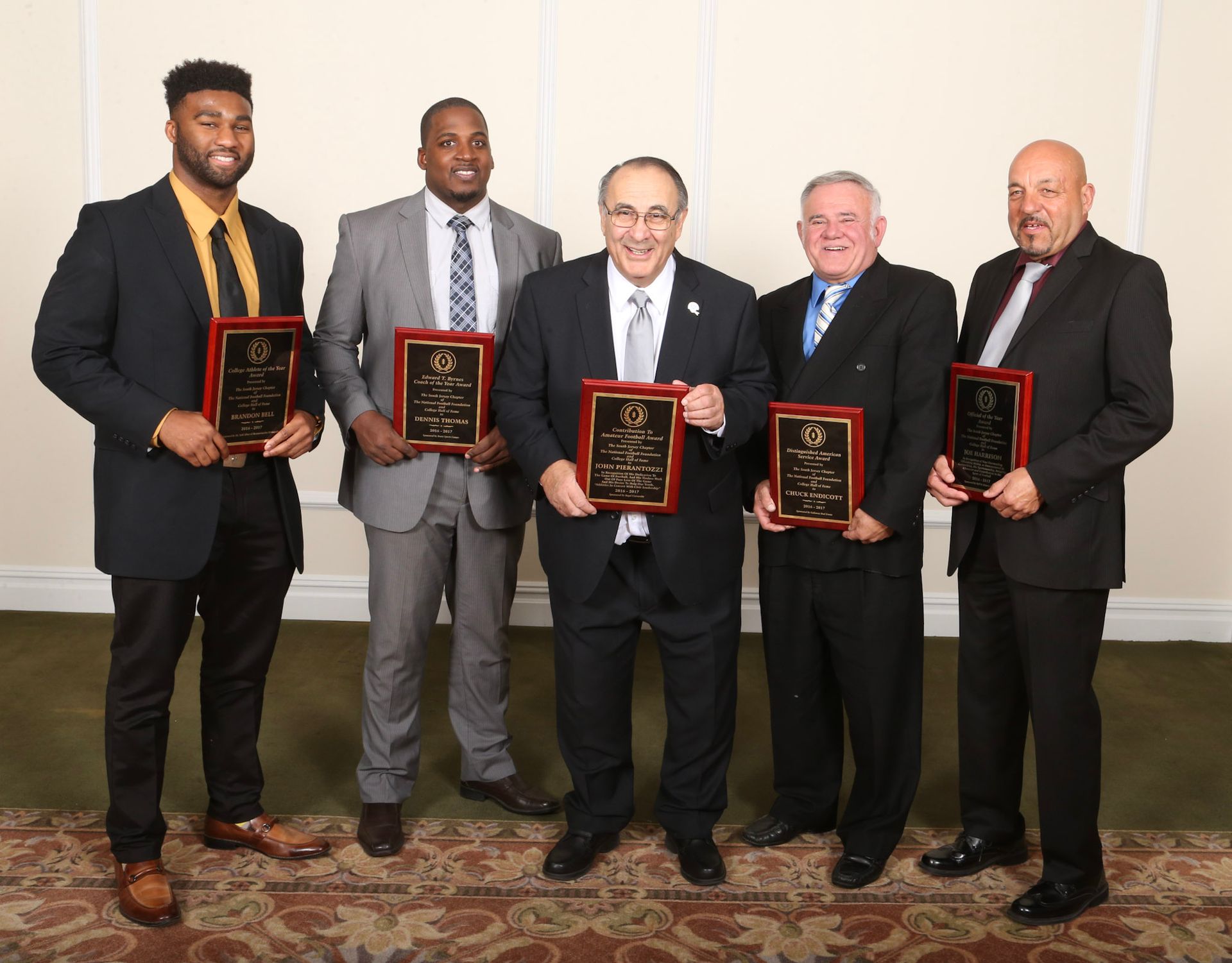 a group of men are posing for a picture while holding plaques