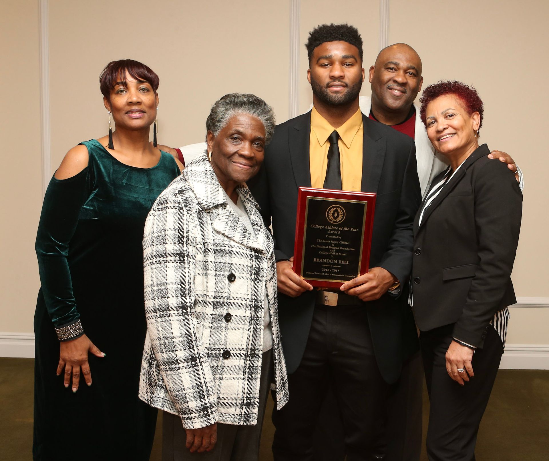 a group of people posing for a picture with a man holding an award