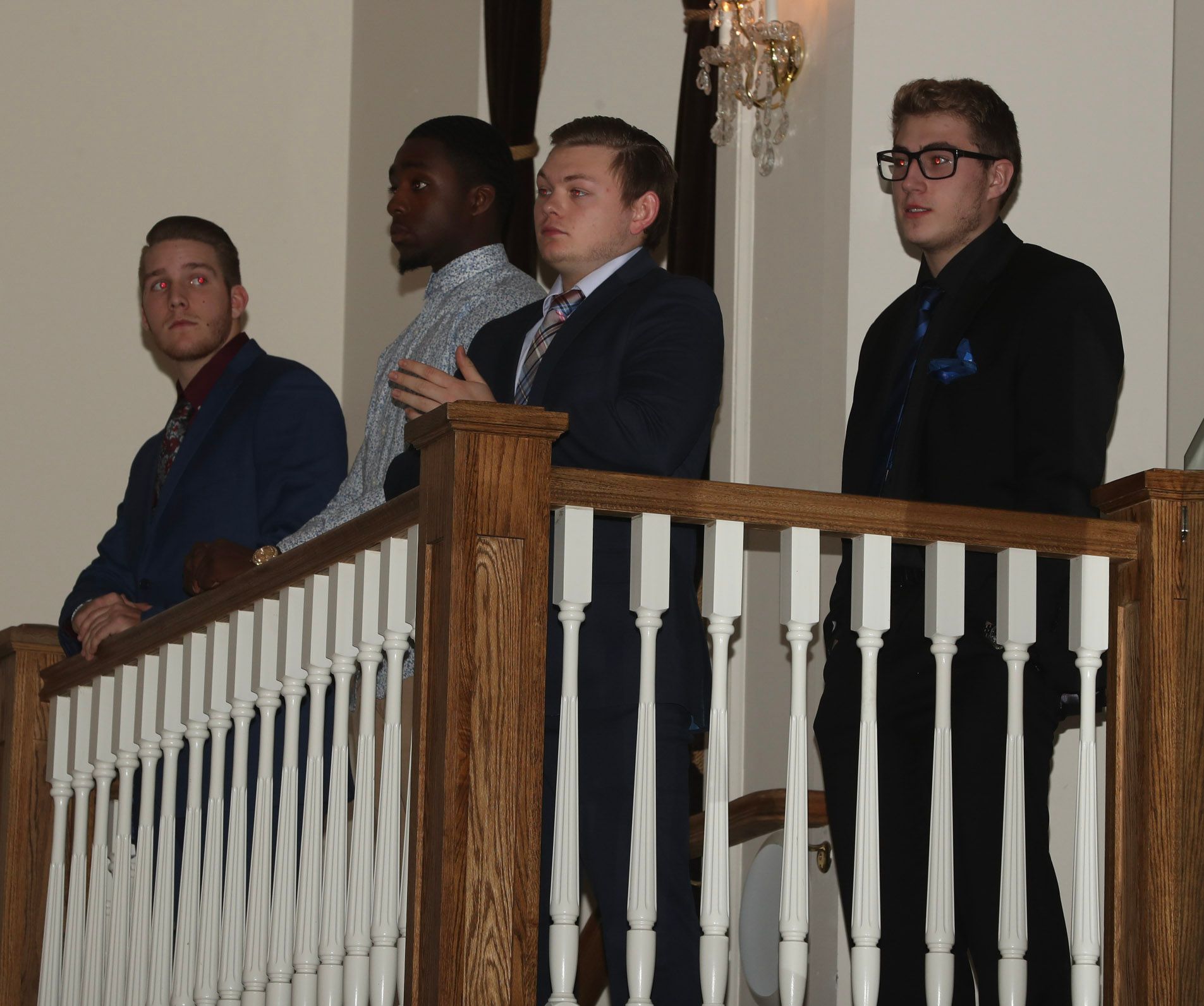 a group of men standing behind a wooden railing