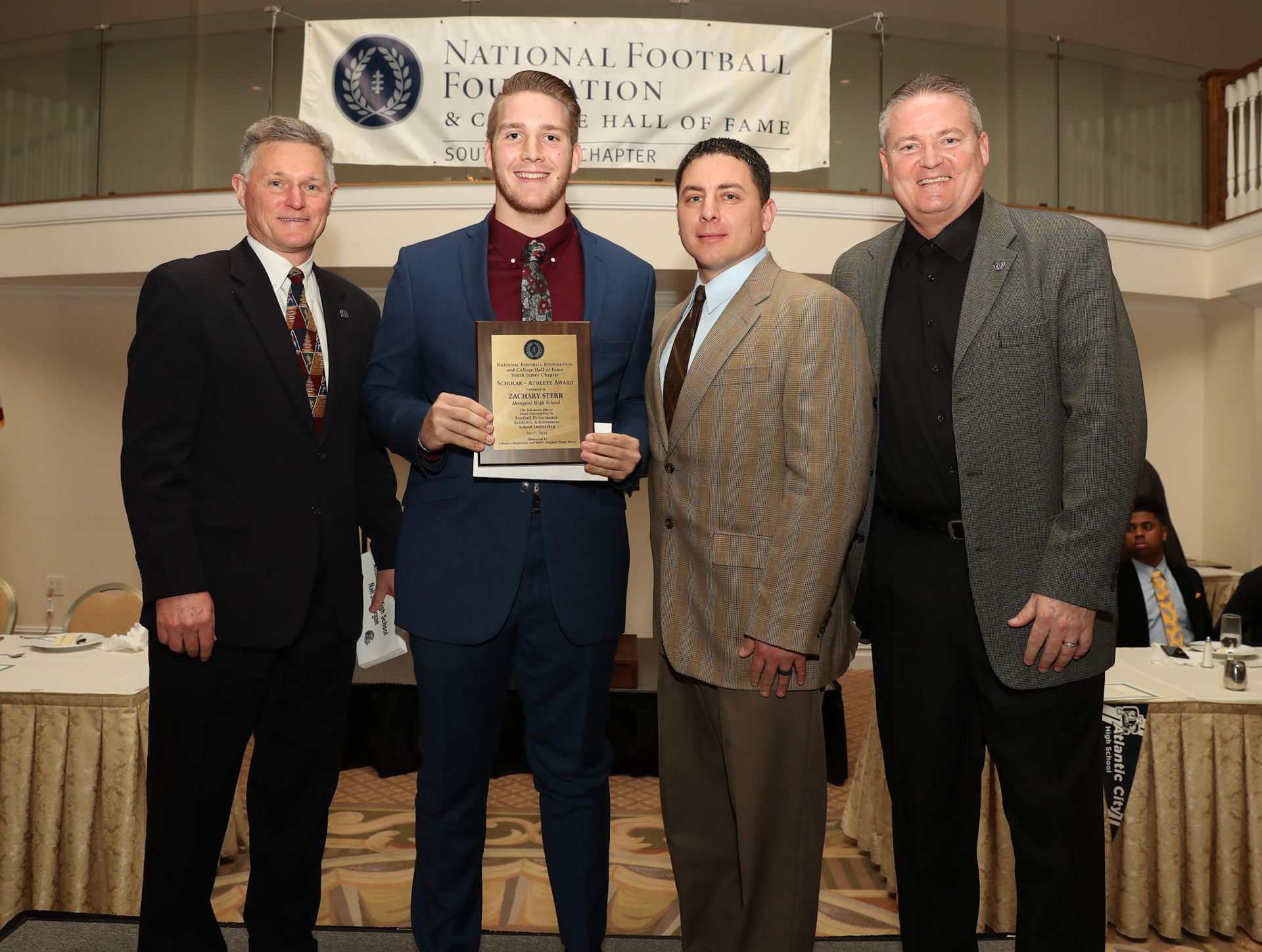a group of men pose for a picture in front of a national actors foundation banner