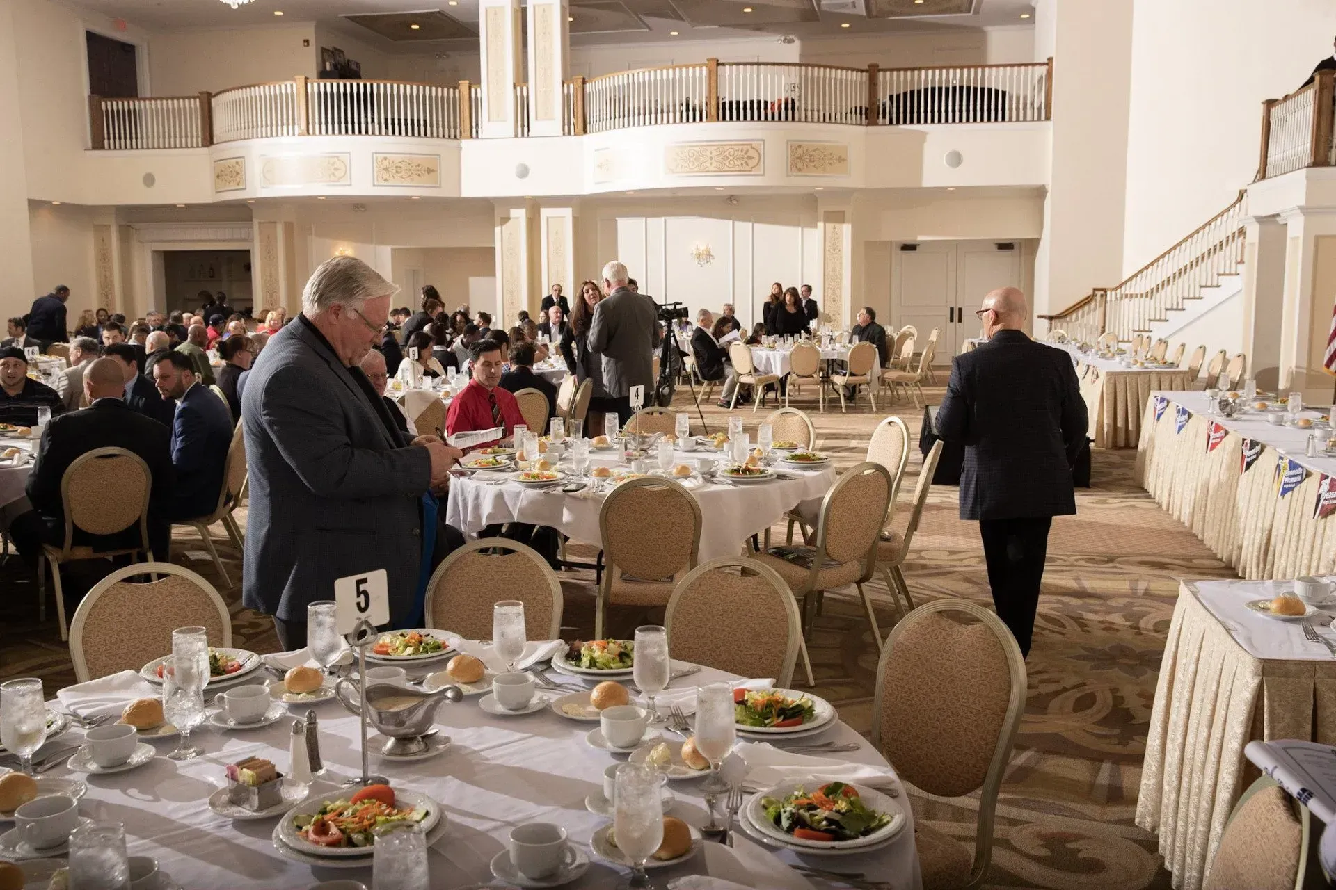 a man stands at a table with a number 5 on it