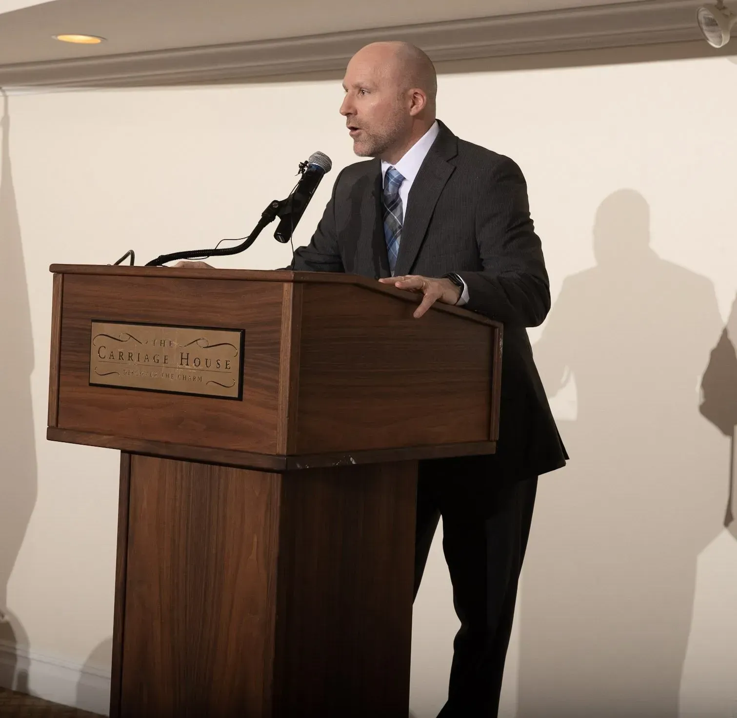 a man in a suit and tie is standing at a podium with a microphone