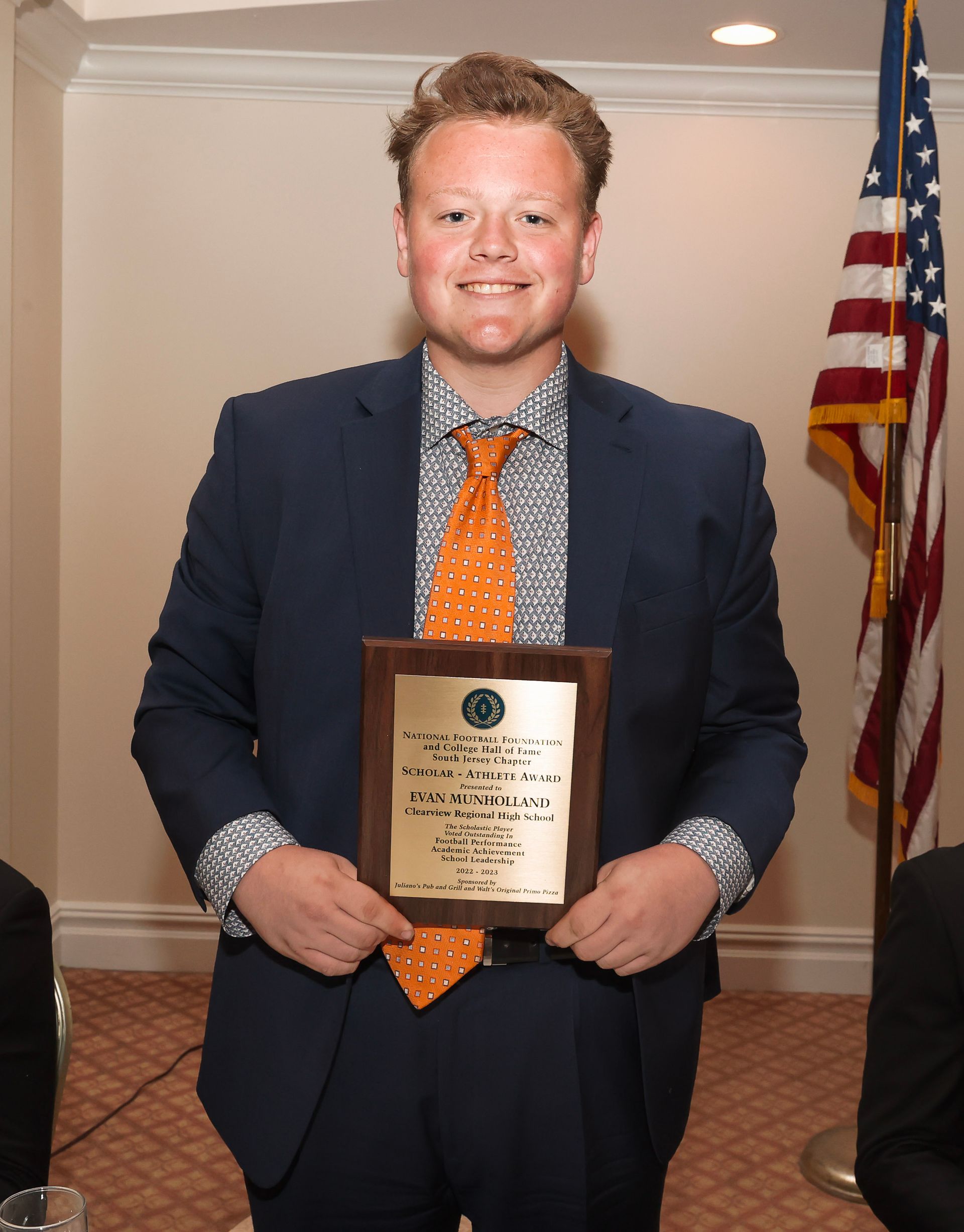 a man in a suit and tie is holding a plaque