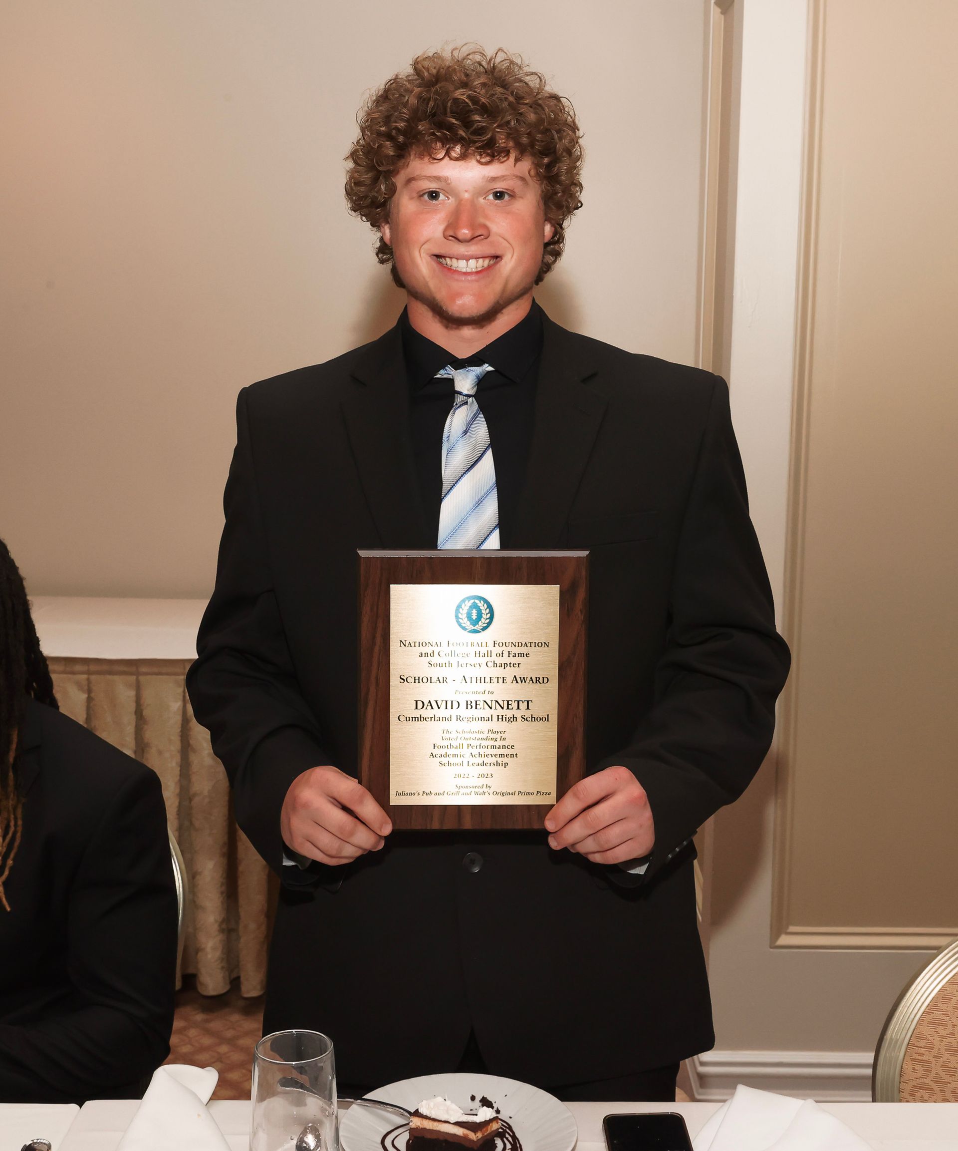a man in a suit and tie is holding a plaque
