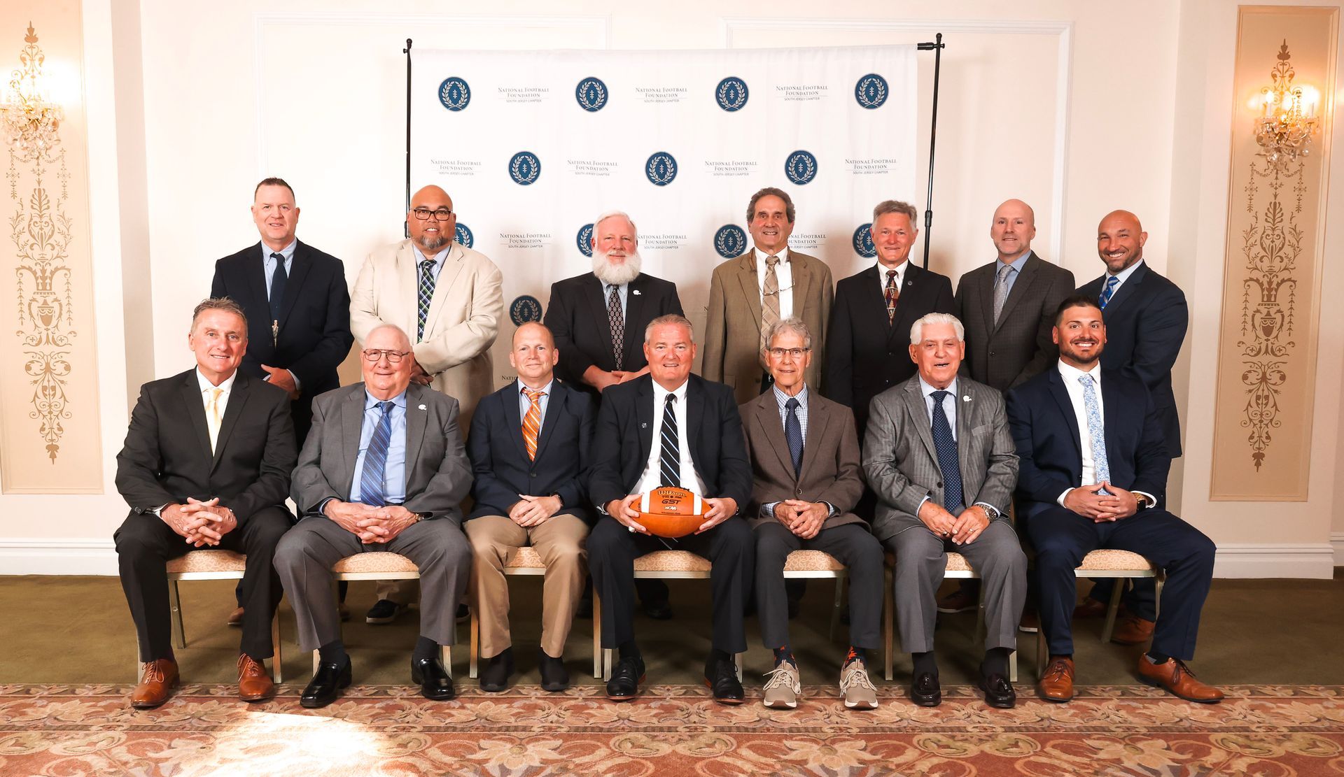 a group of men in suits and ties pose for a photo