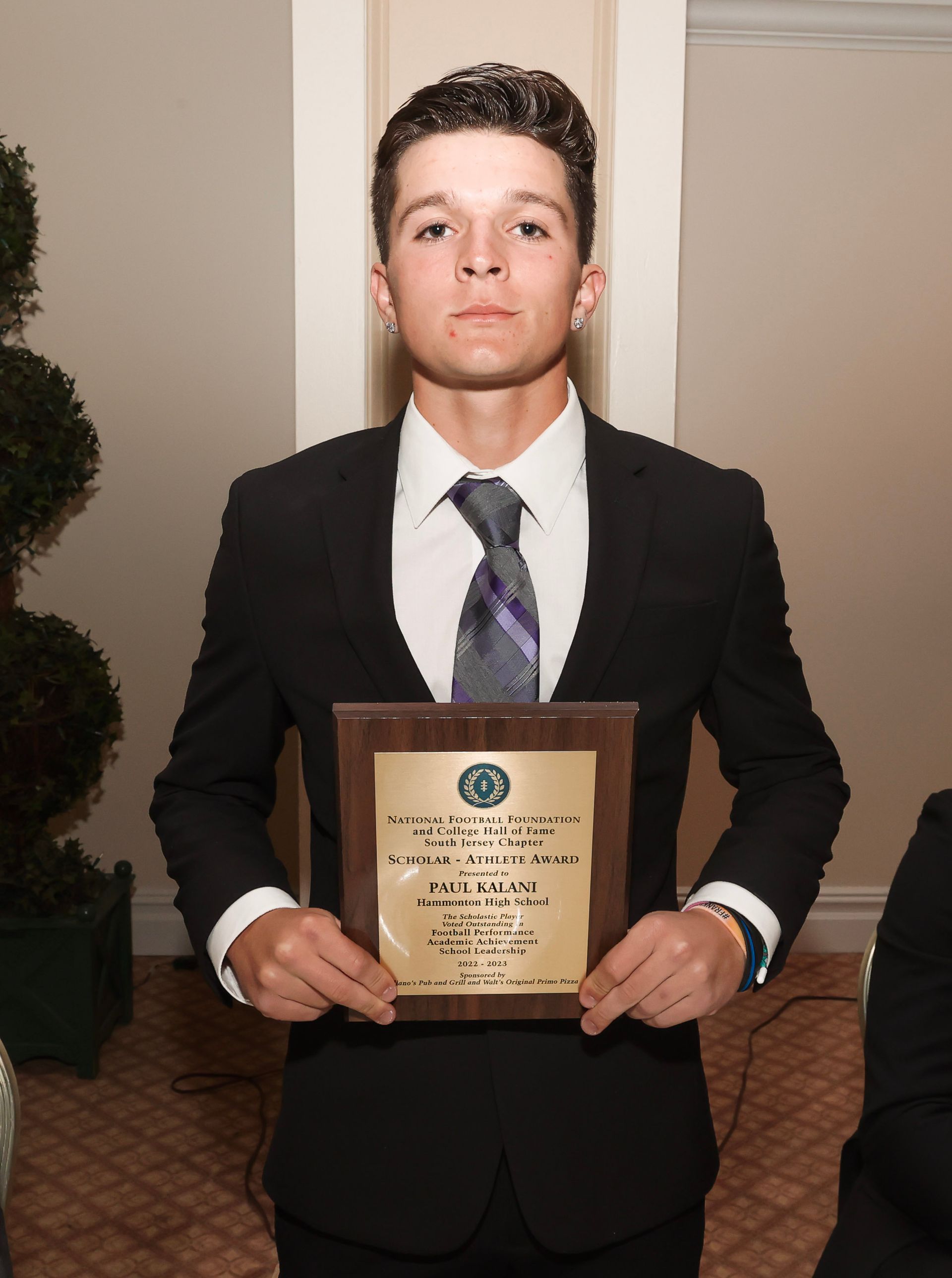 a man in a suit and tie is holding a plaque