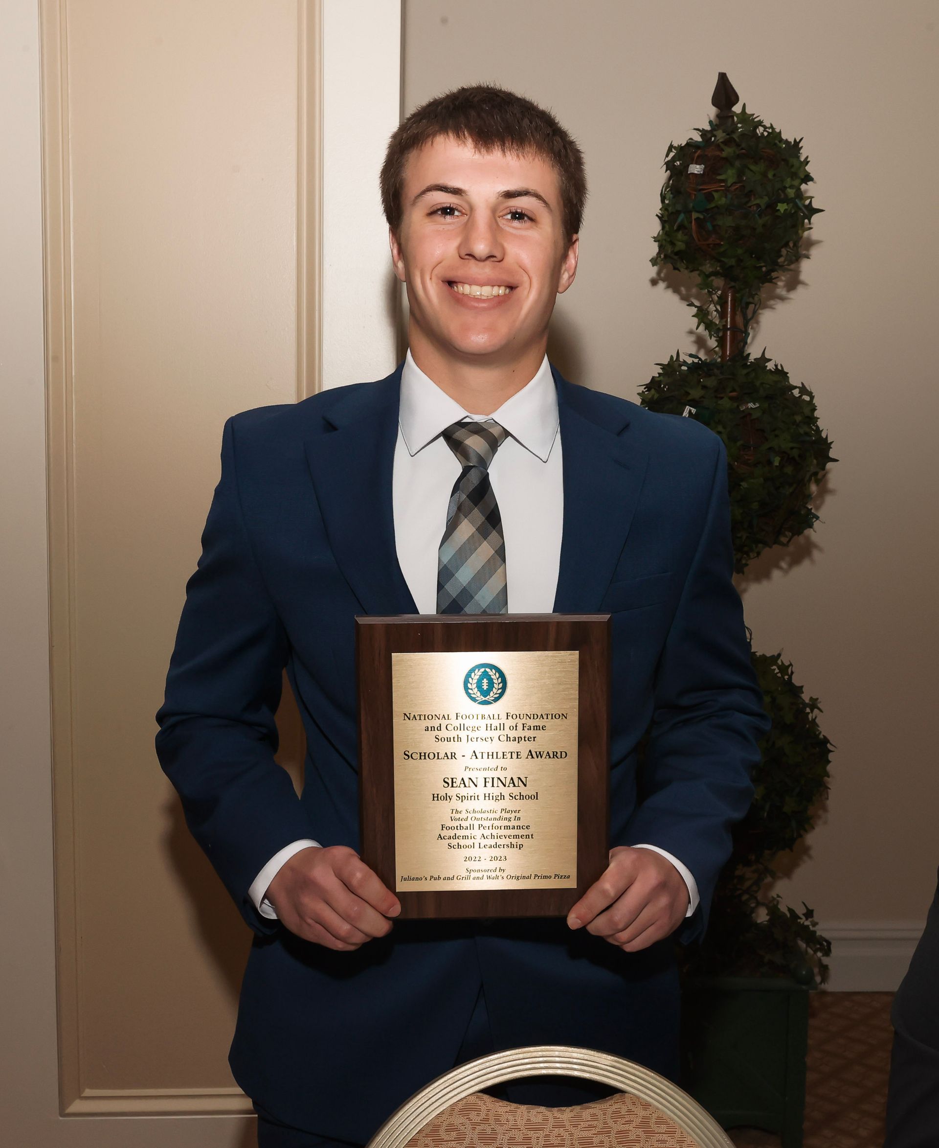 a man in a suit and tie is holding a plaque