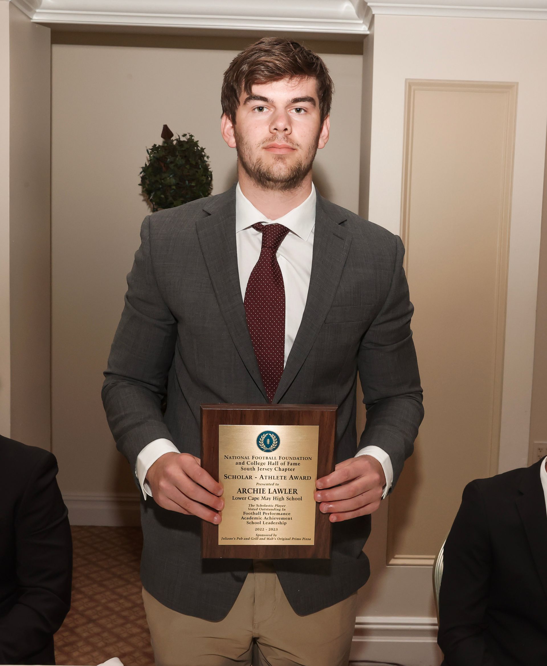 a man in a suit and tie is holding a plaque