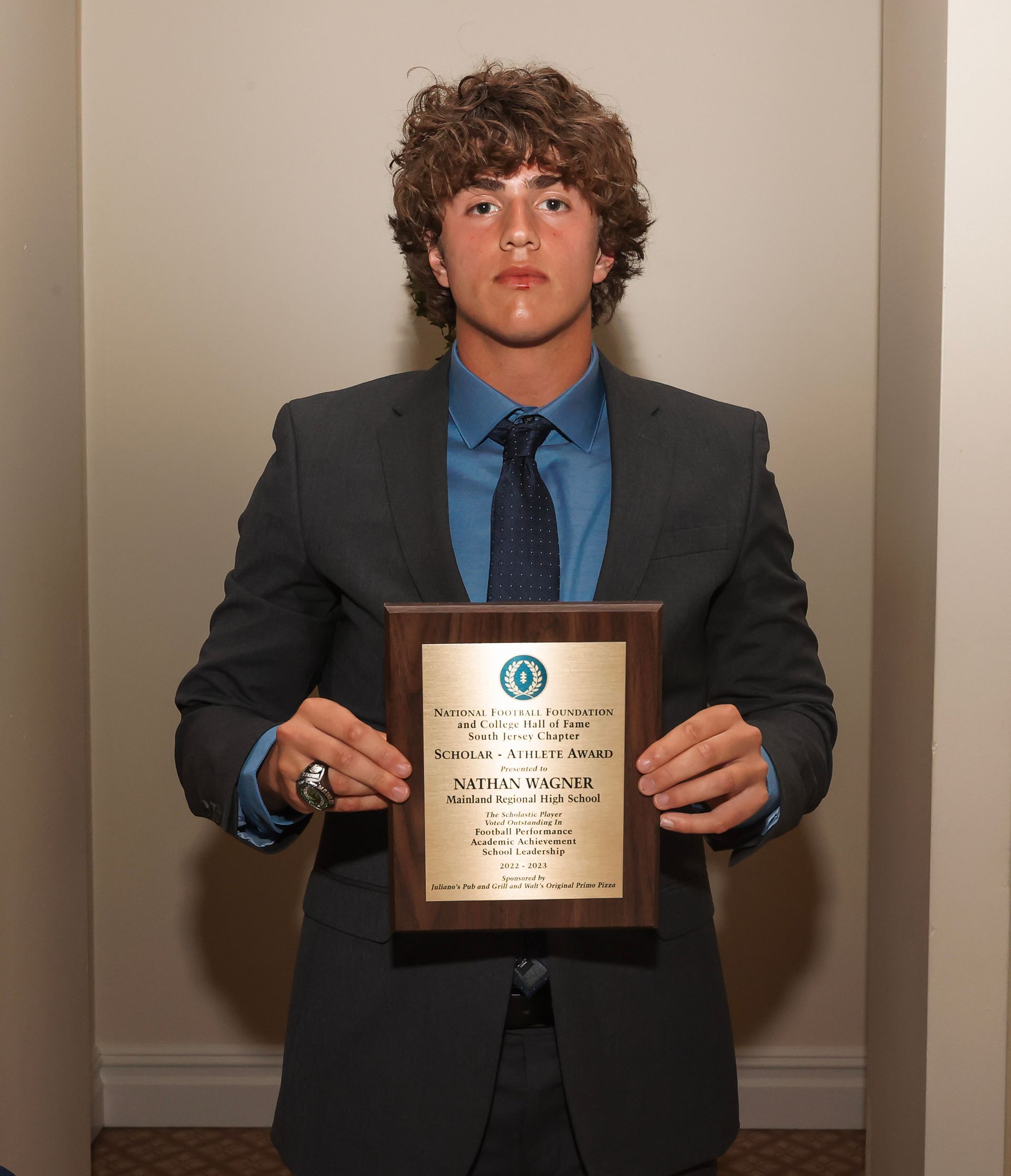 a man in a suit and tie is holding a plaque