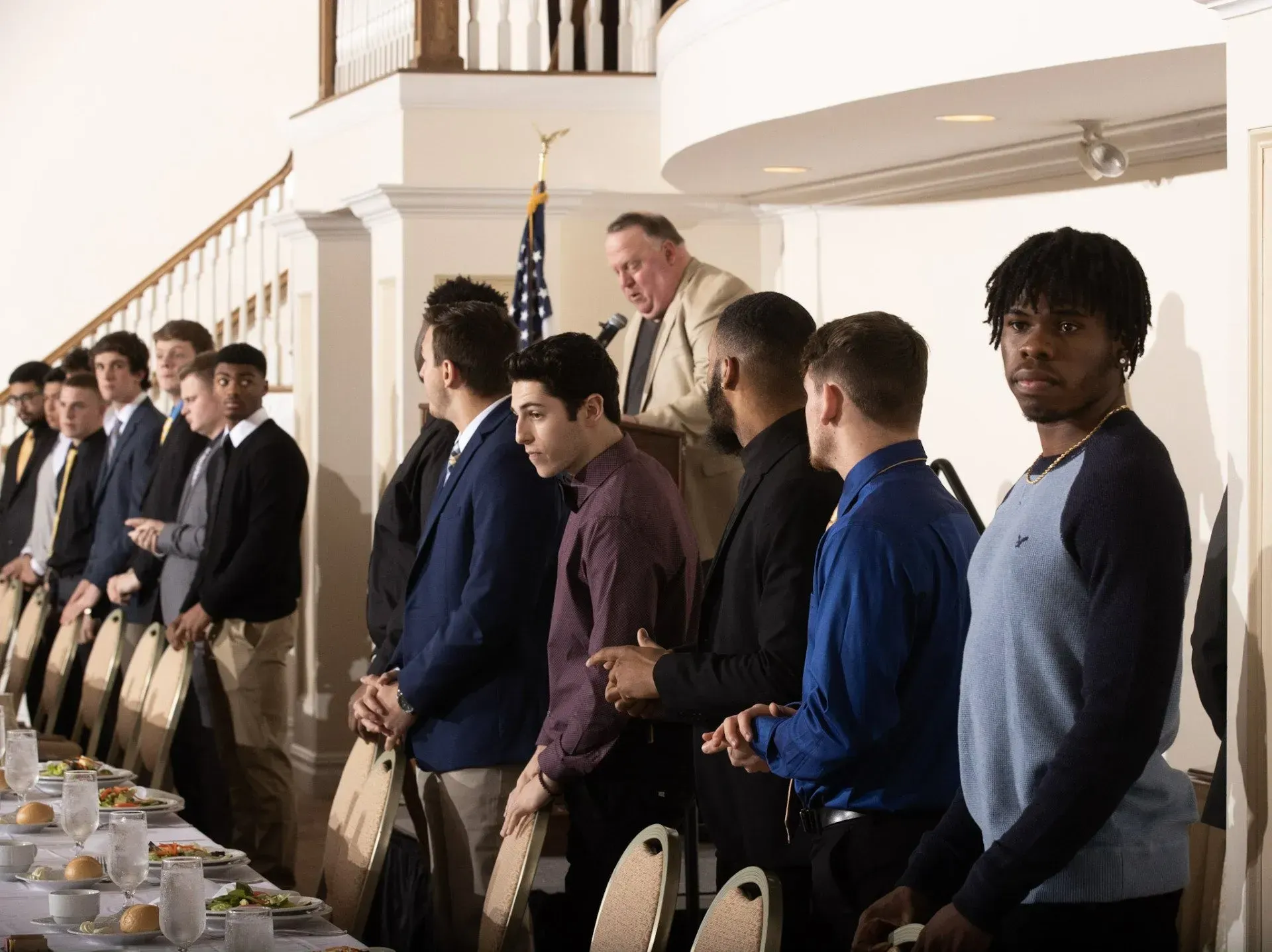 a group of men standing in front of a long table