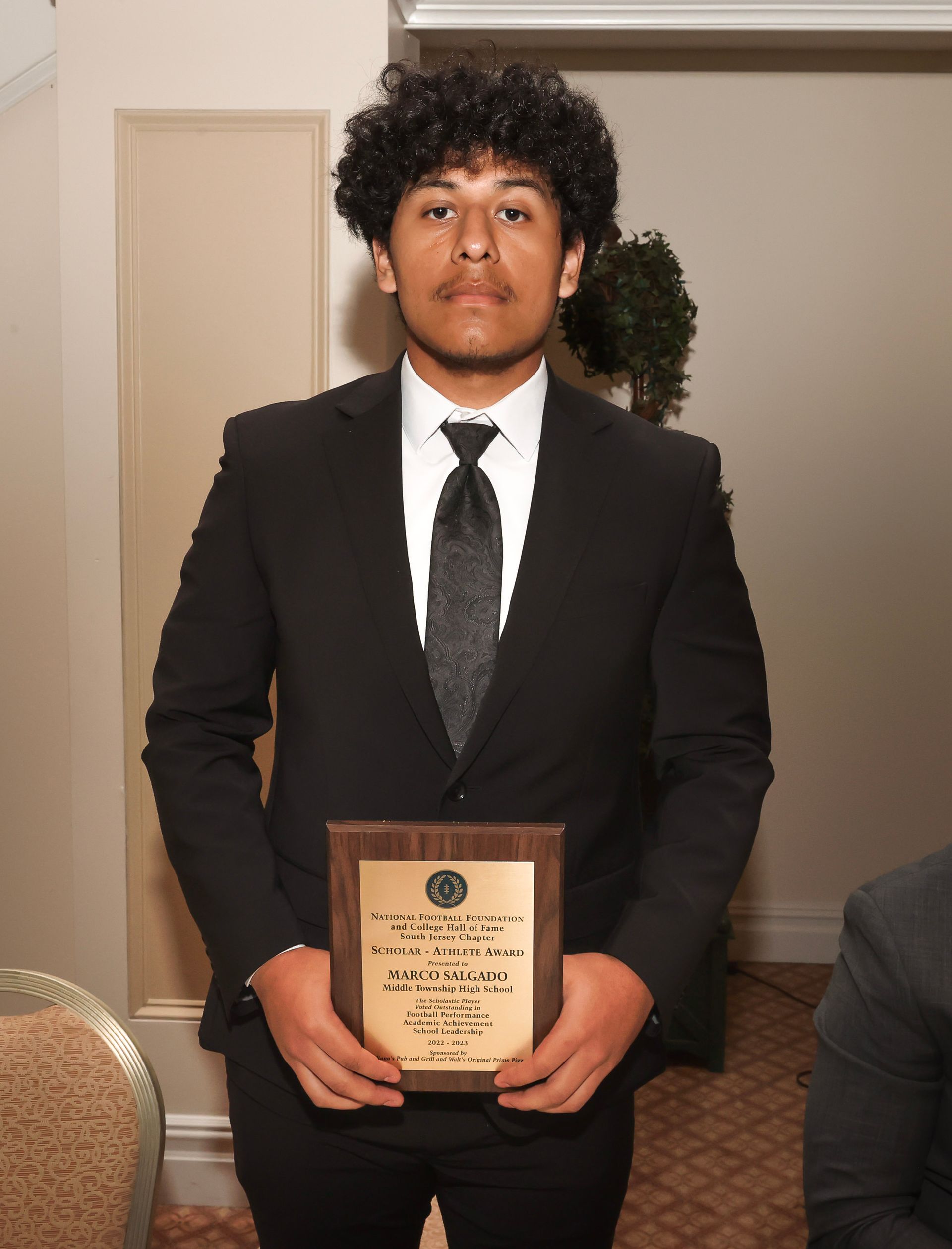 a man in a suit and tie is holding a plaque