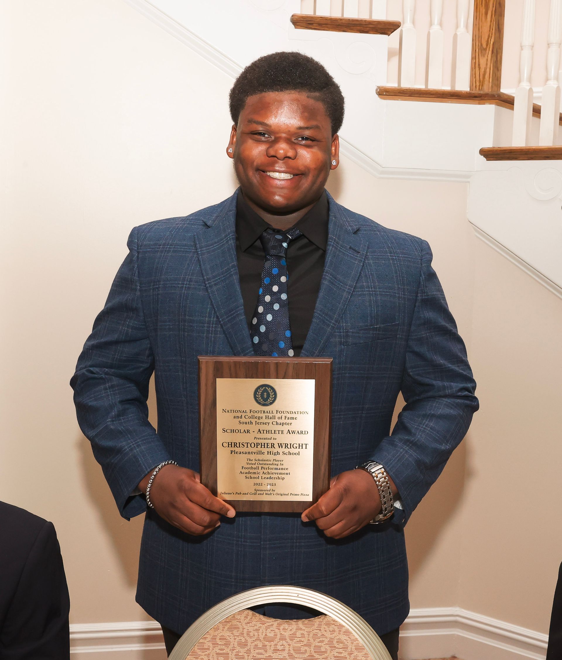 a man in a suit and tie is holding a plaque