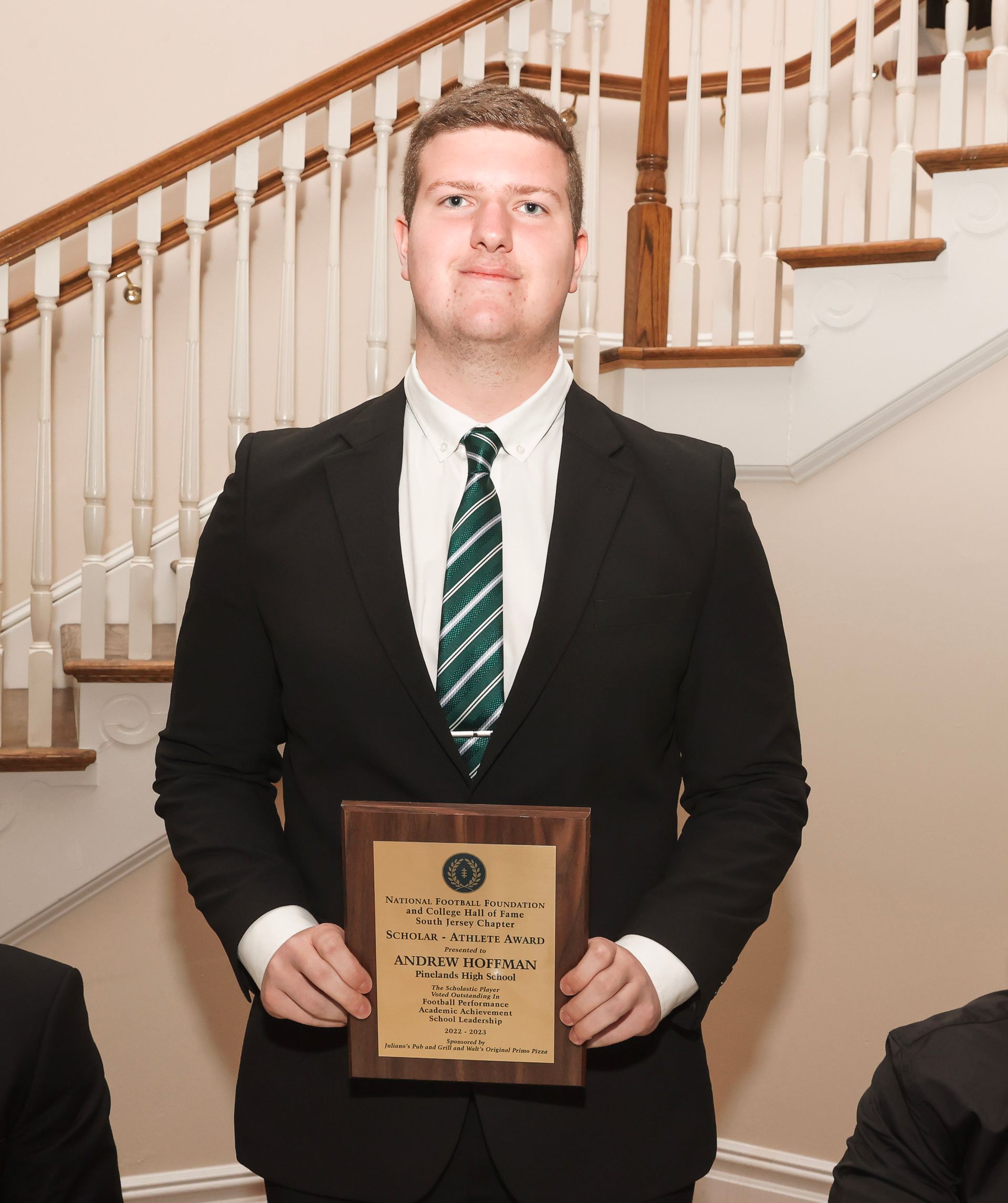 a man in a suit and tie is holding a plaque