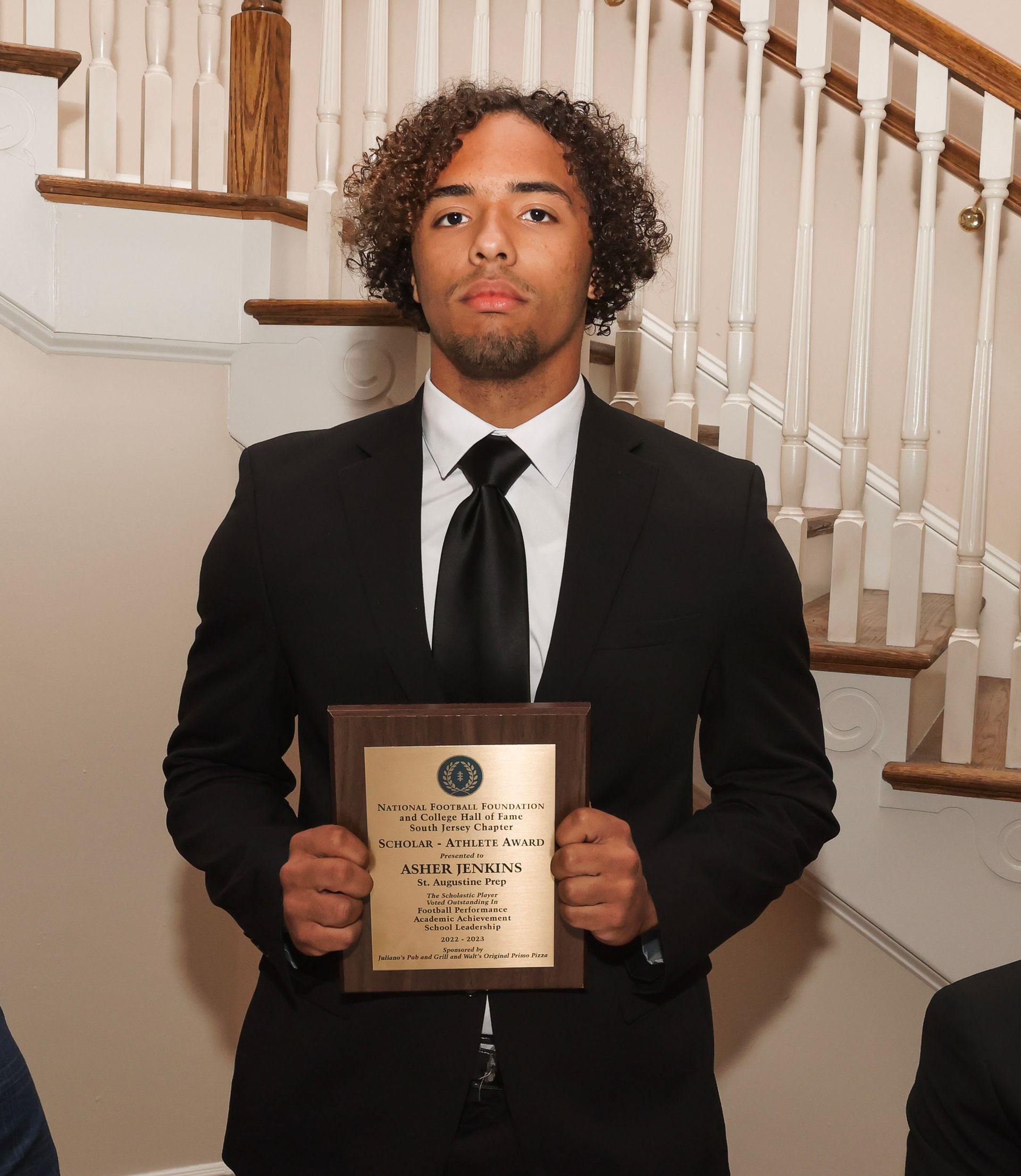 a man in a suit and tie is holding a plaque