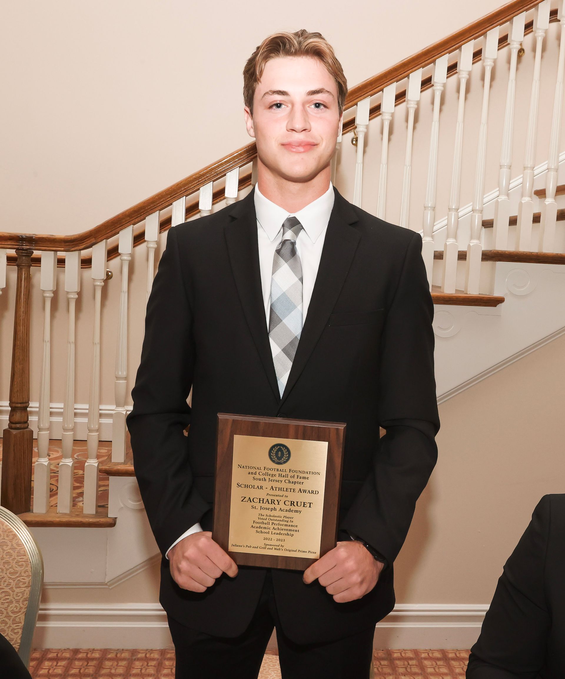 a man in a suit and tie is holding a plaque