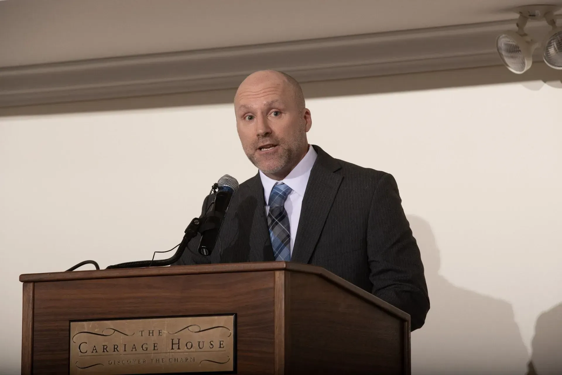 a man in a suit and tie is standing at a podium giving a speech