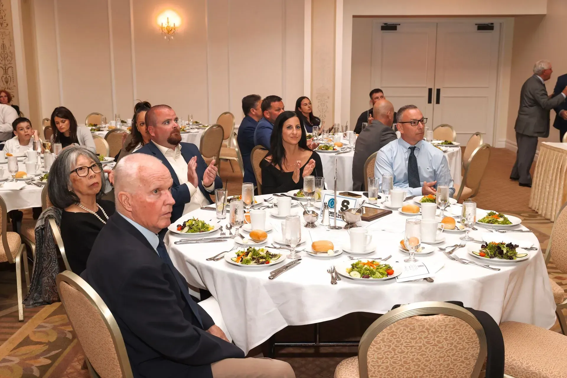 a group of people sitting at tables with plates of food