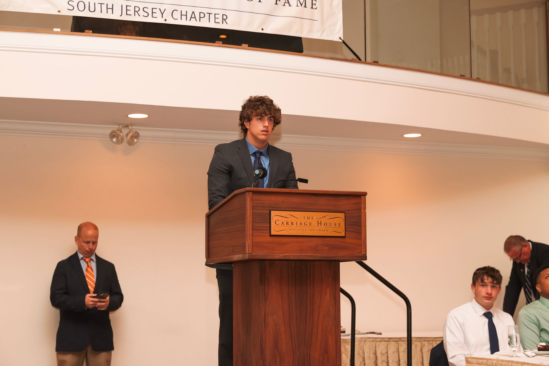 a man stands at a podium with a sign behind him that says shut like a state
