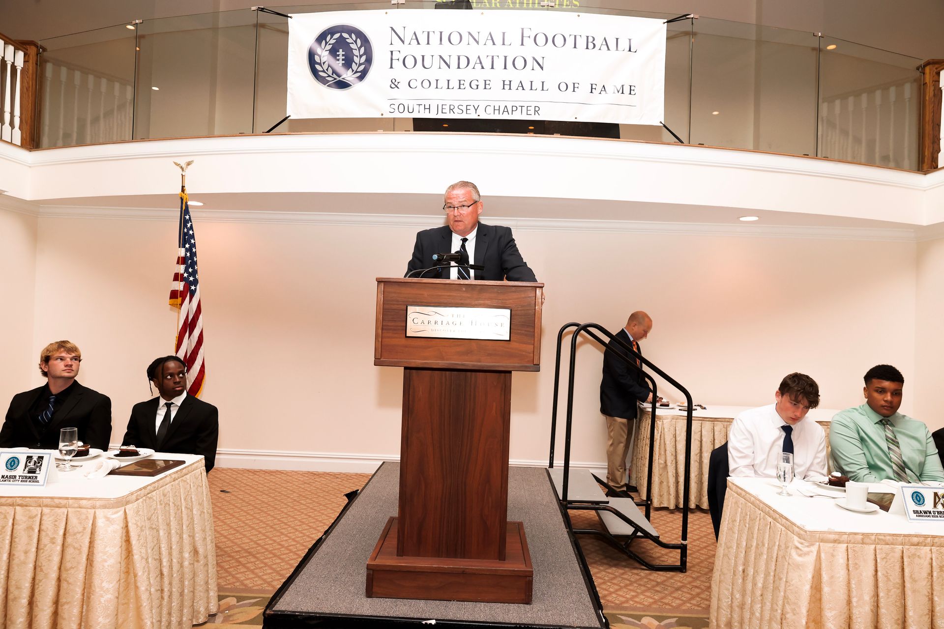 a man stands at a podium in front of a national foundation banner