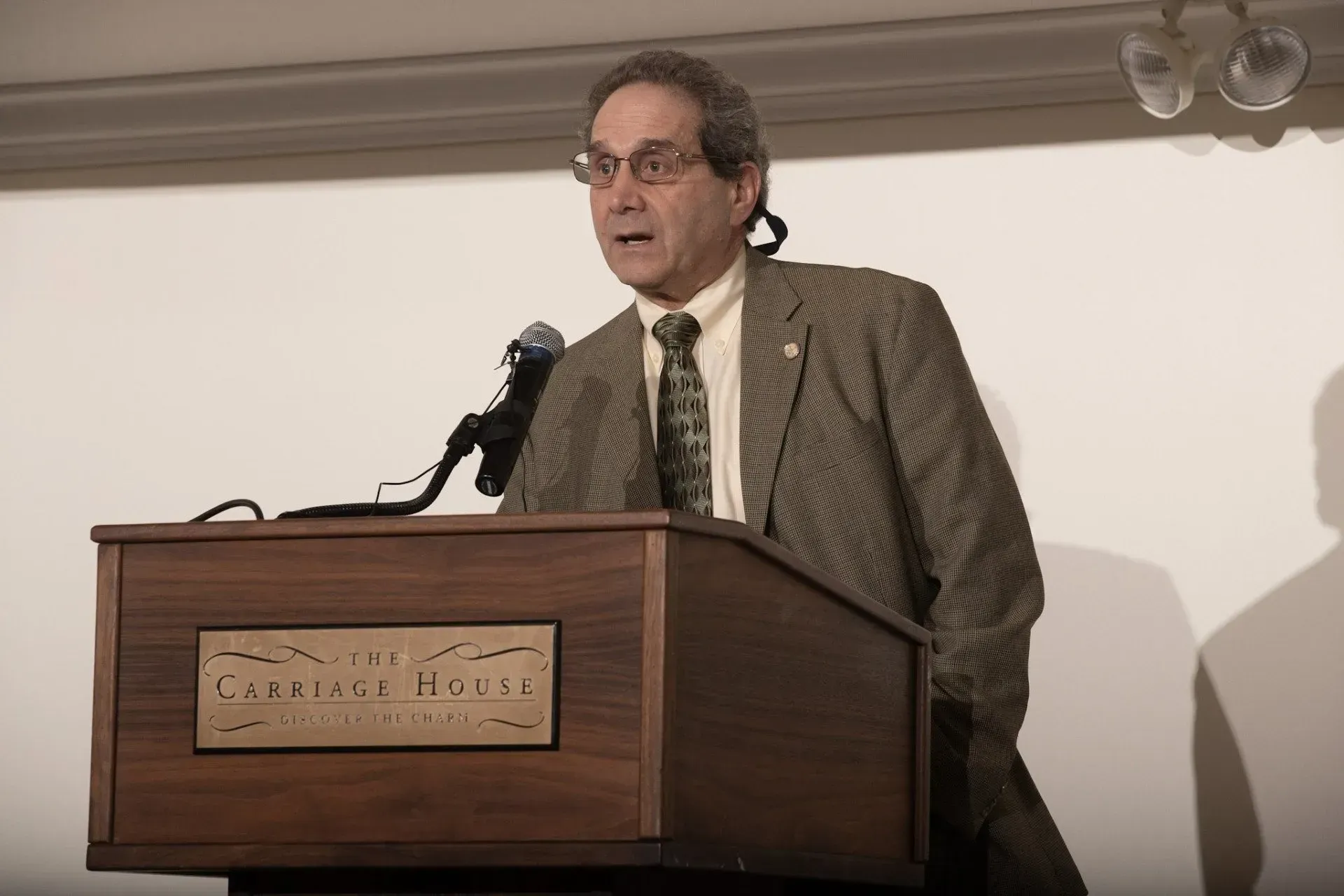 a man stands behind a podium that says carlton on it