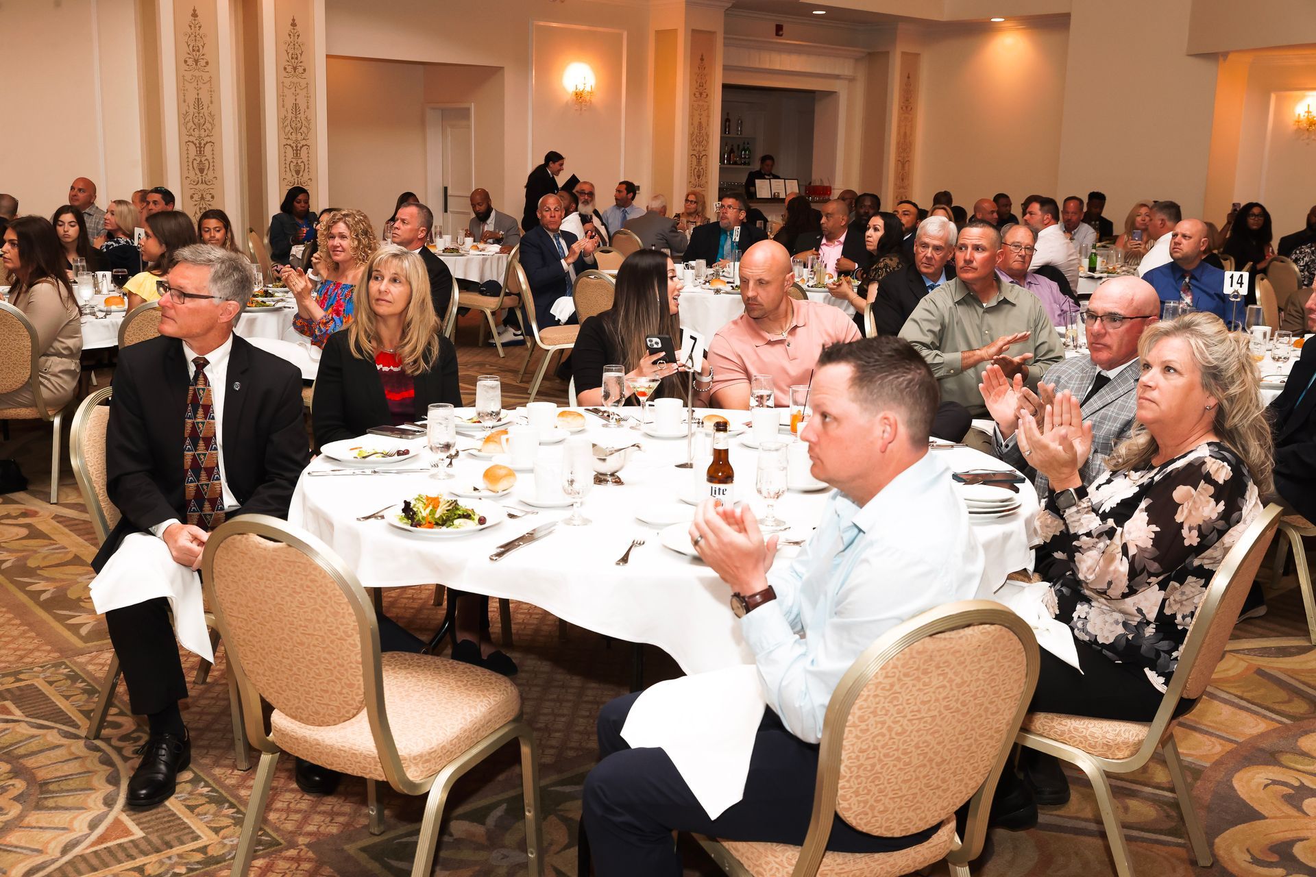 a large group of people are sitting at tables in a large room
