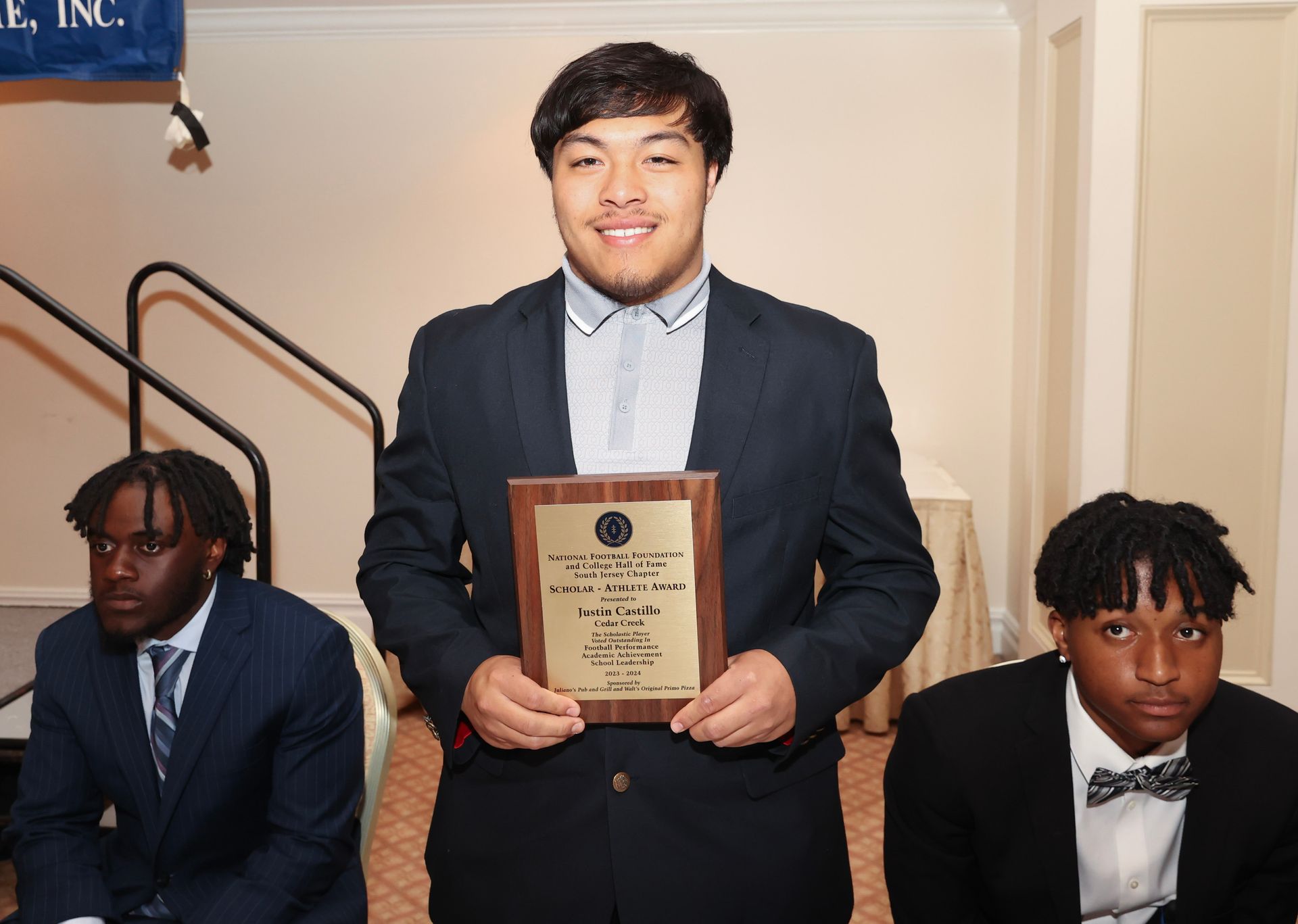 A man in a suit is holding a plaque in his hands