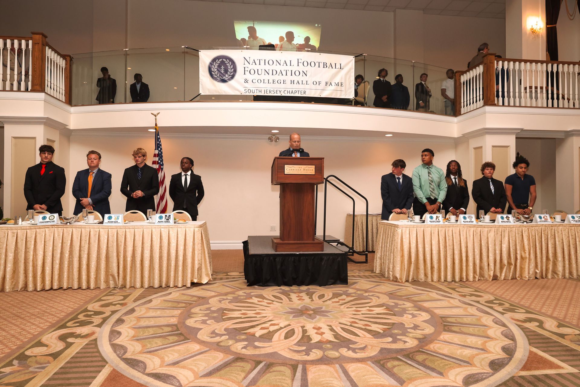 a man stands at a podium in front of a group of people