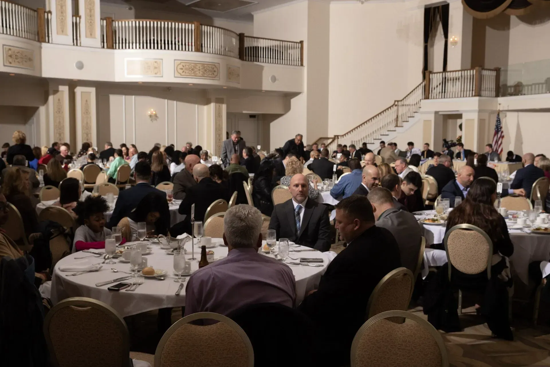 a large group of people are sitting at tables in a large room