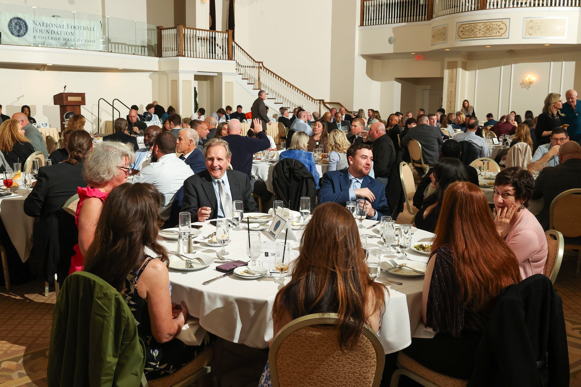 A large group of people are sitting at tables in a large room
