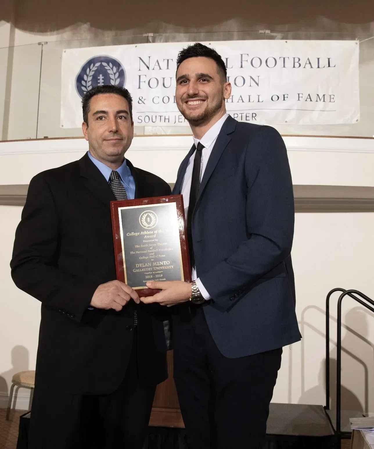 two men standing in front of a sign that says national football hall of fame