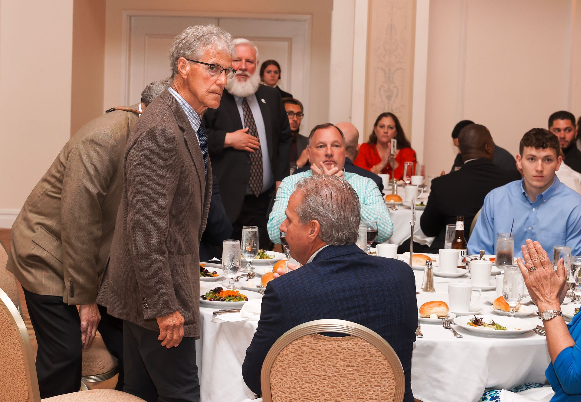 a group of people sitting at tables with plates of food