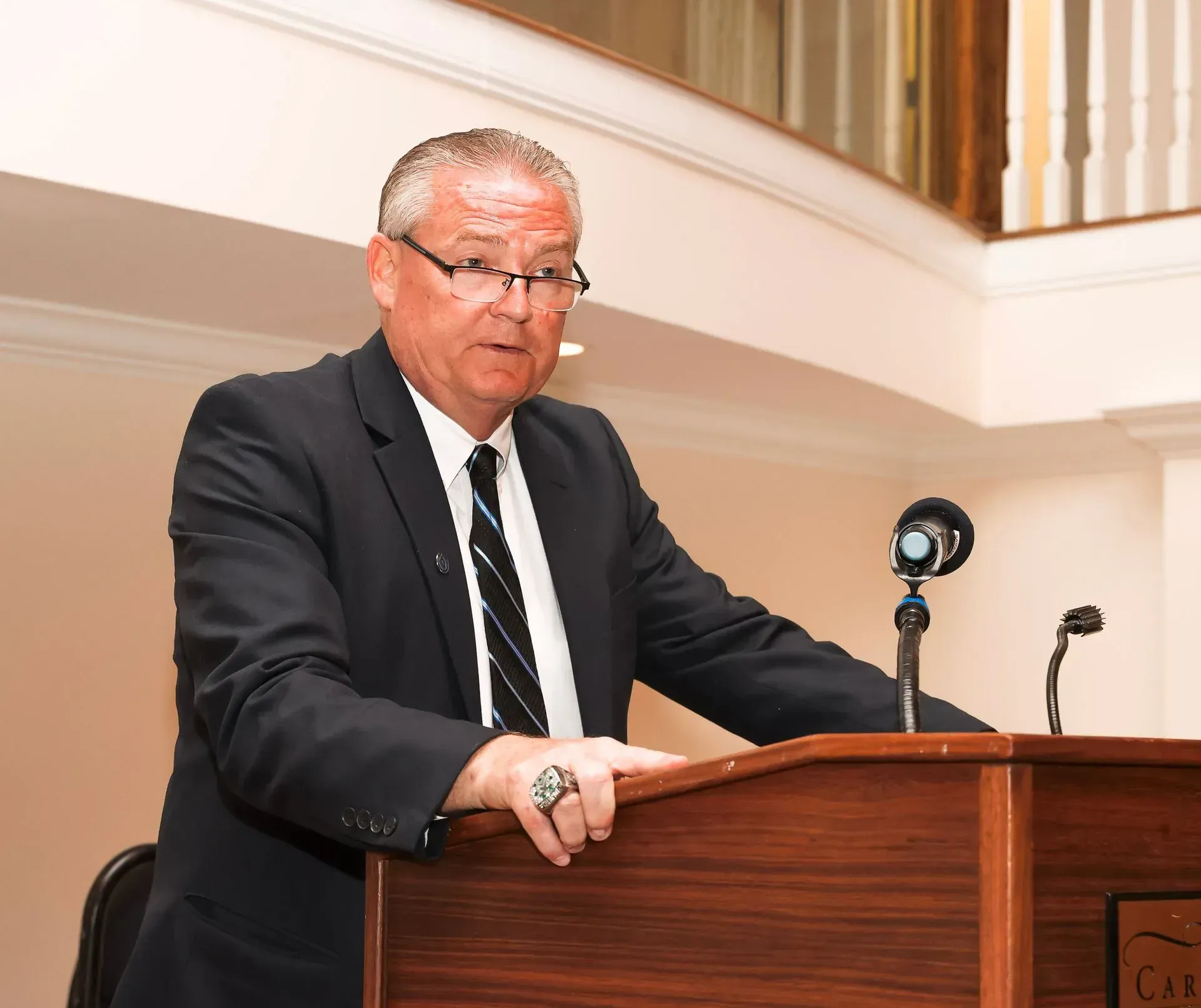 a man in a suit and tie stands at a podium