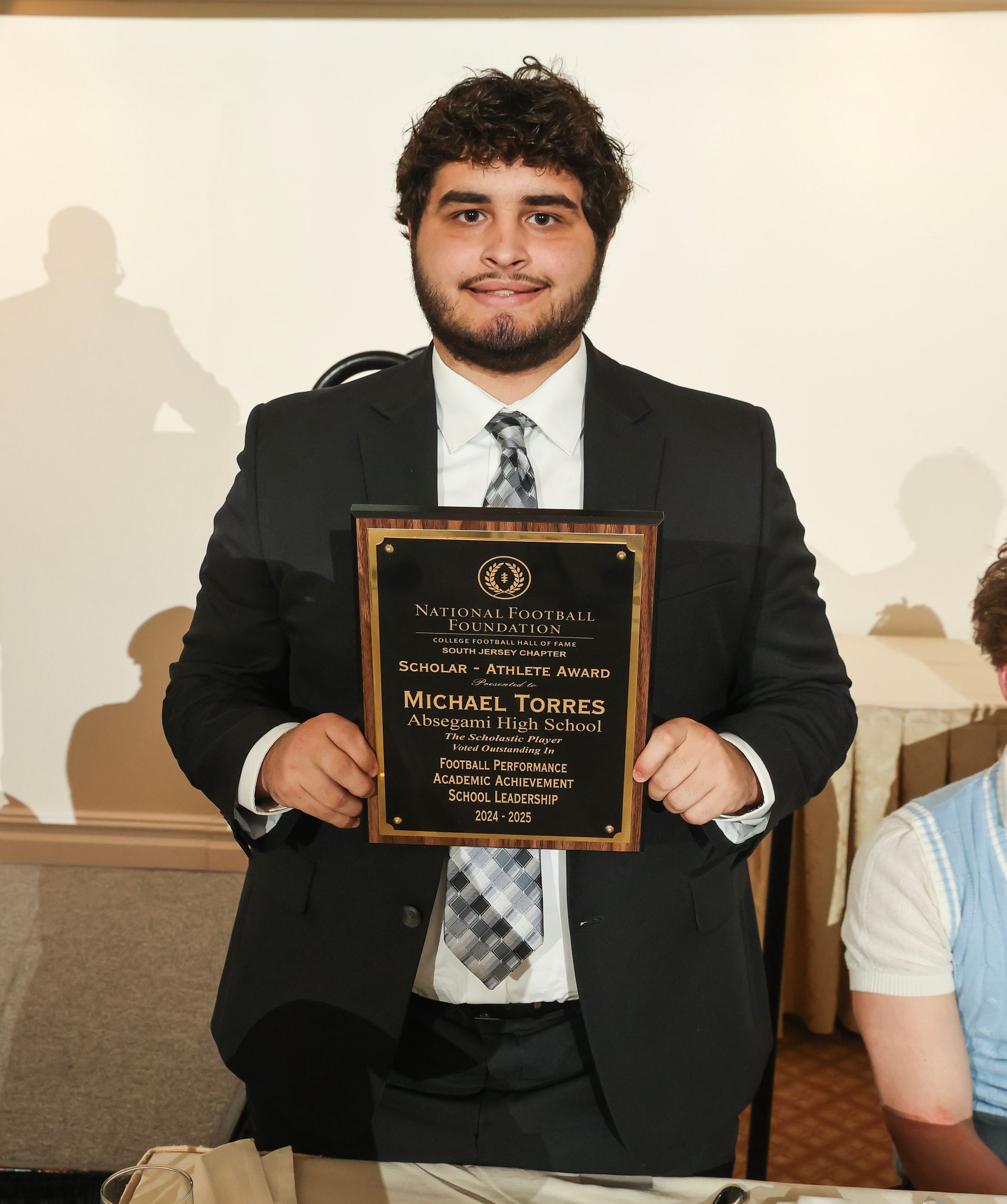 michael torres of absegami high school holding an award plaque 