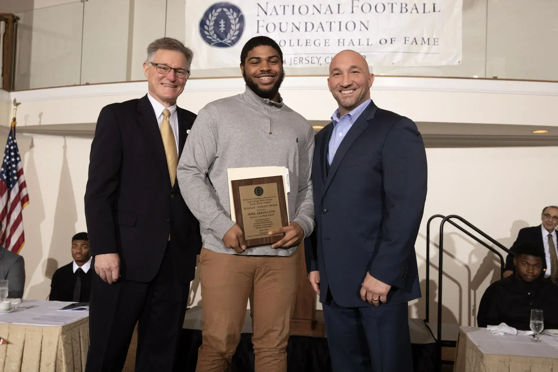 a man is holding a plaque that says ' national football foundation ' on it