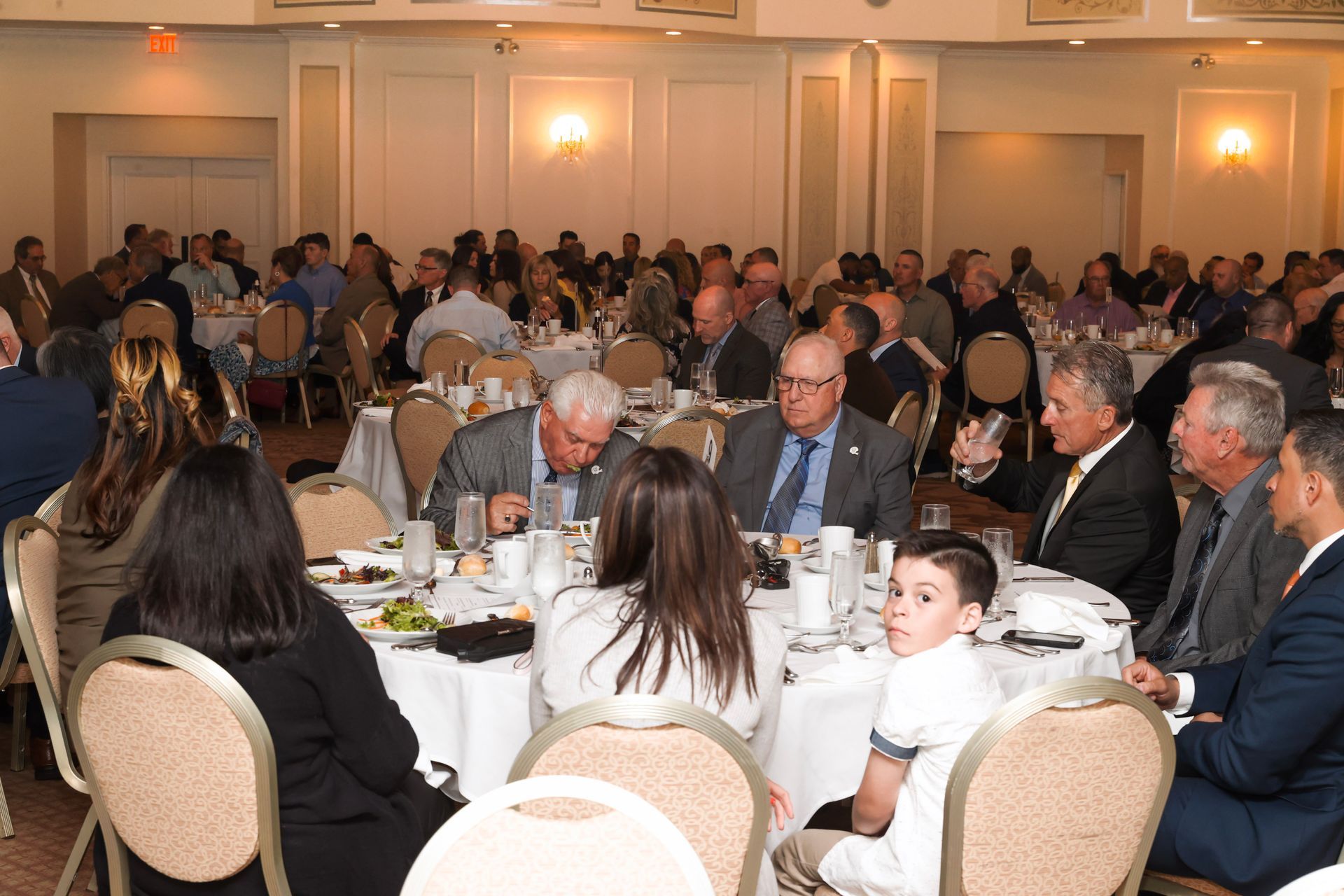 a group of people are sitting at tables in a large room
