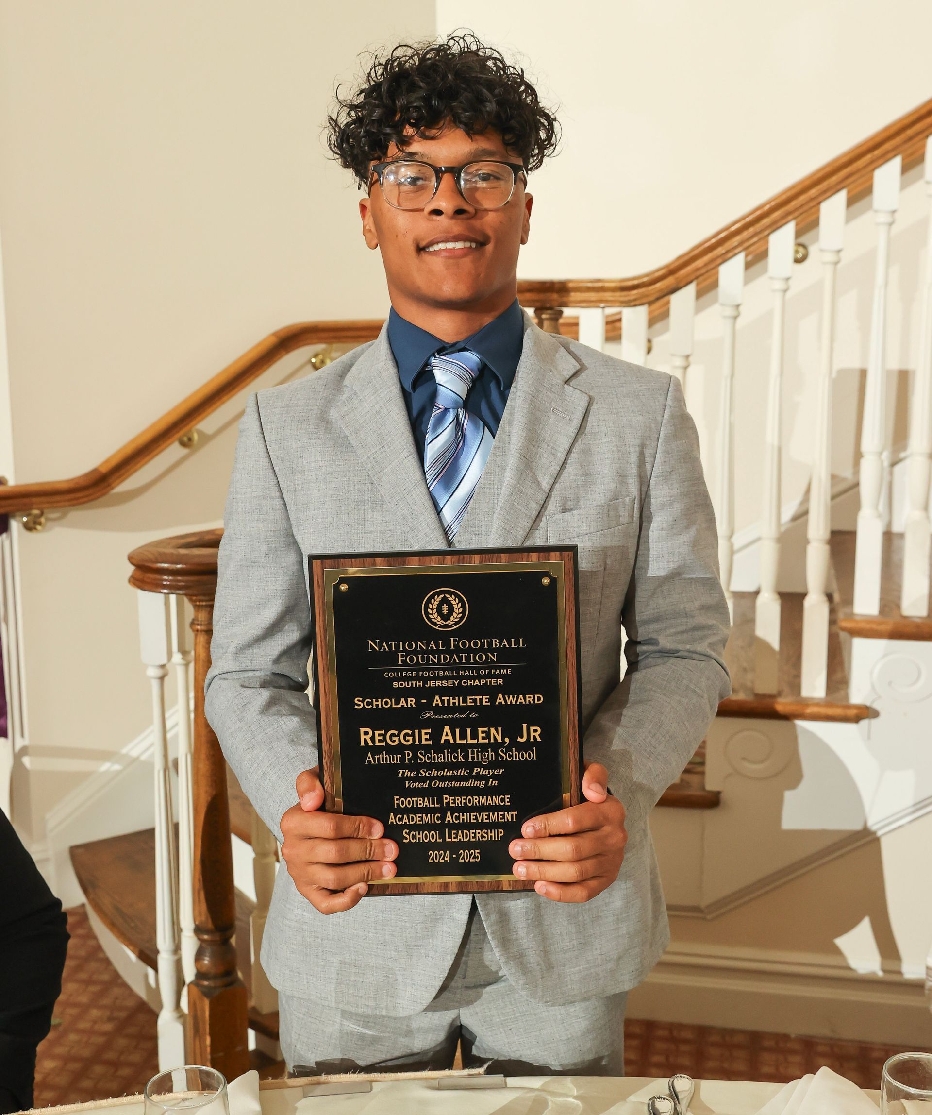 reggie allen of arthur p. schalick high school holding an award plaque 